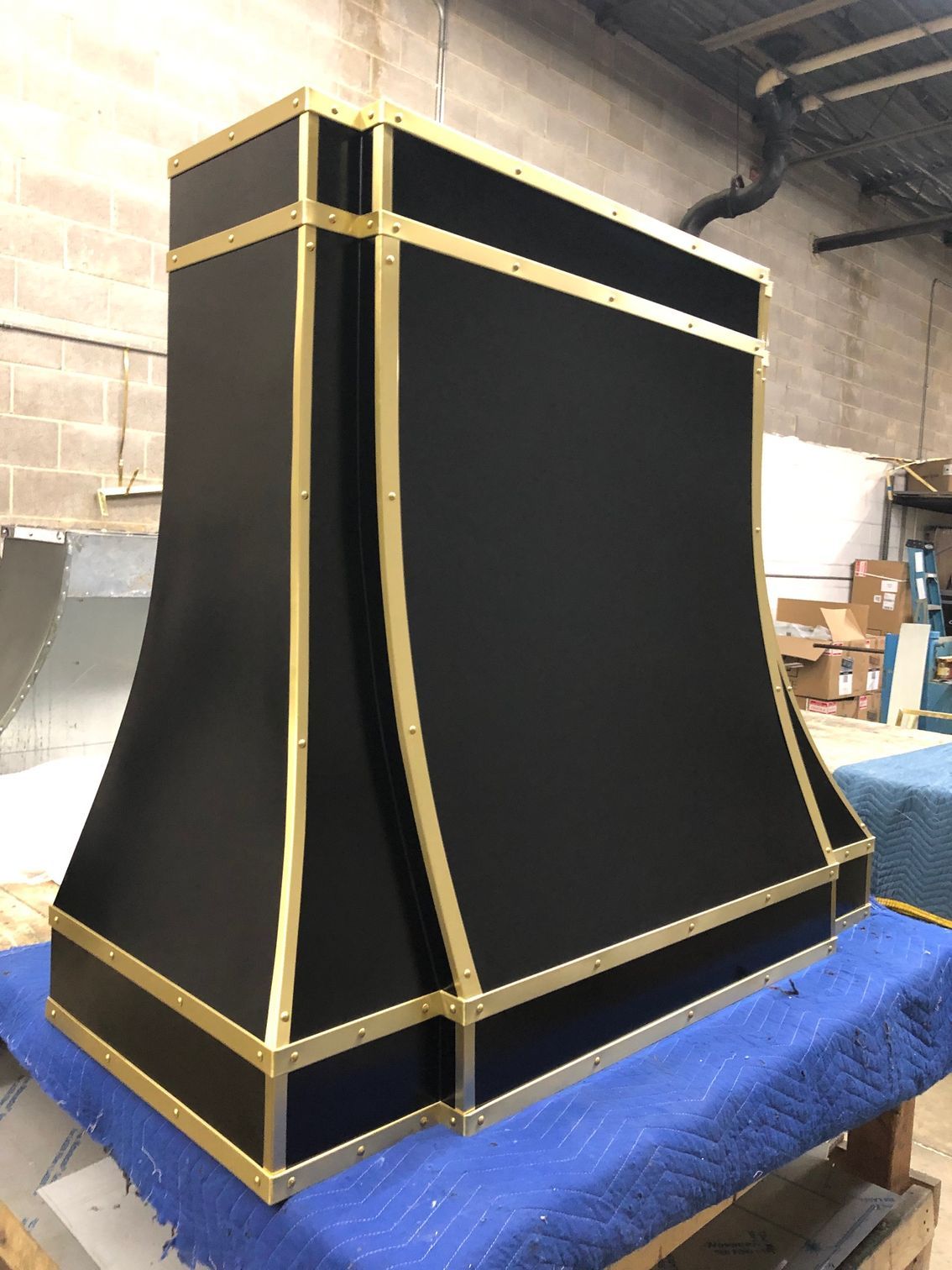 A black and gold hood is sitting on top of a blue table.