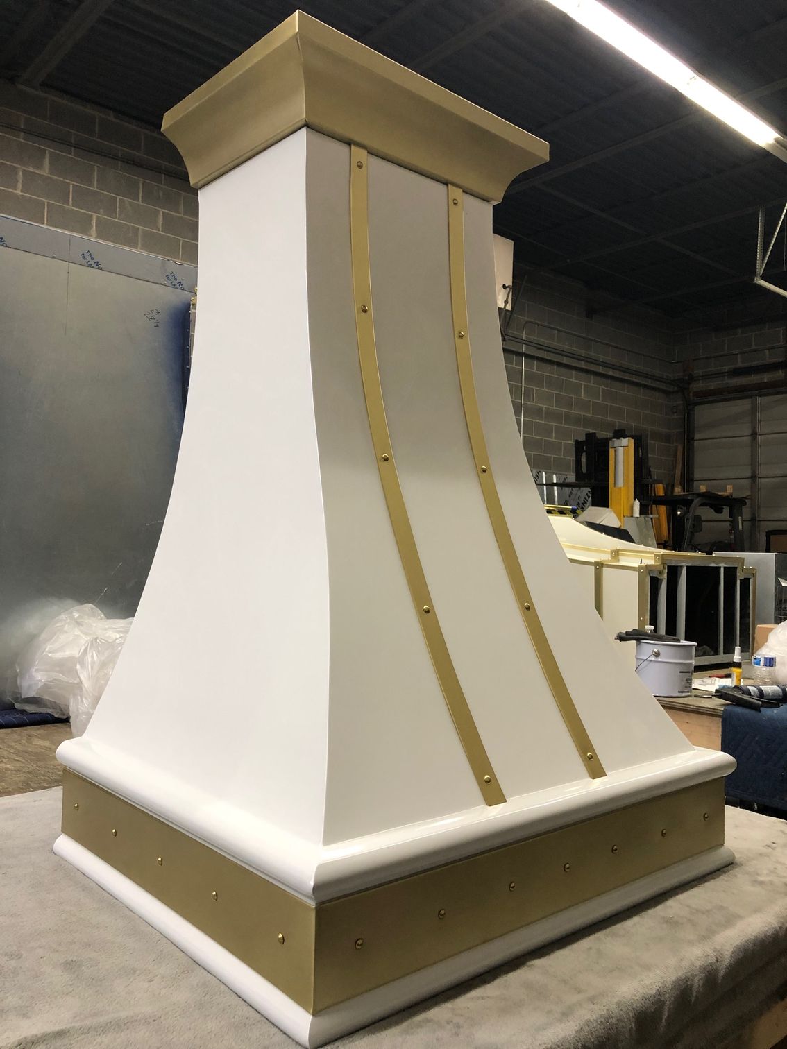 A white and gold hood is sitting on a table.