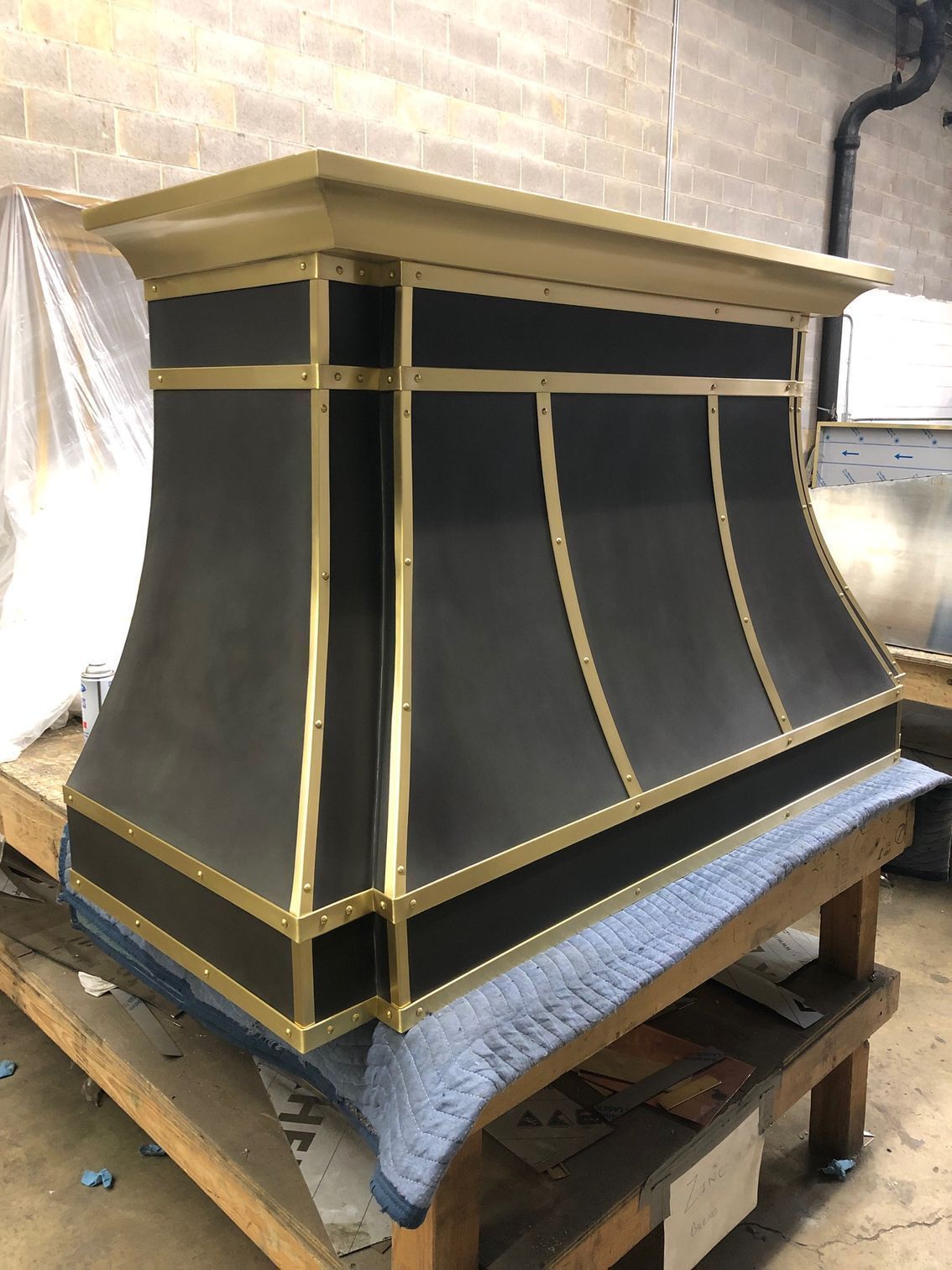 A black and gold hood is sitting on top of a wooden table.