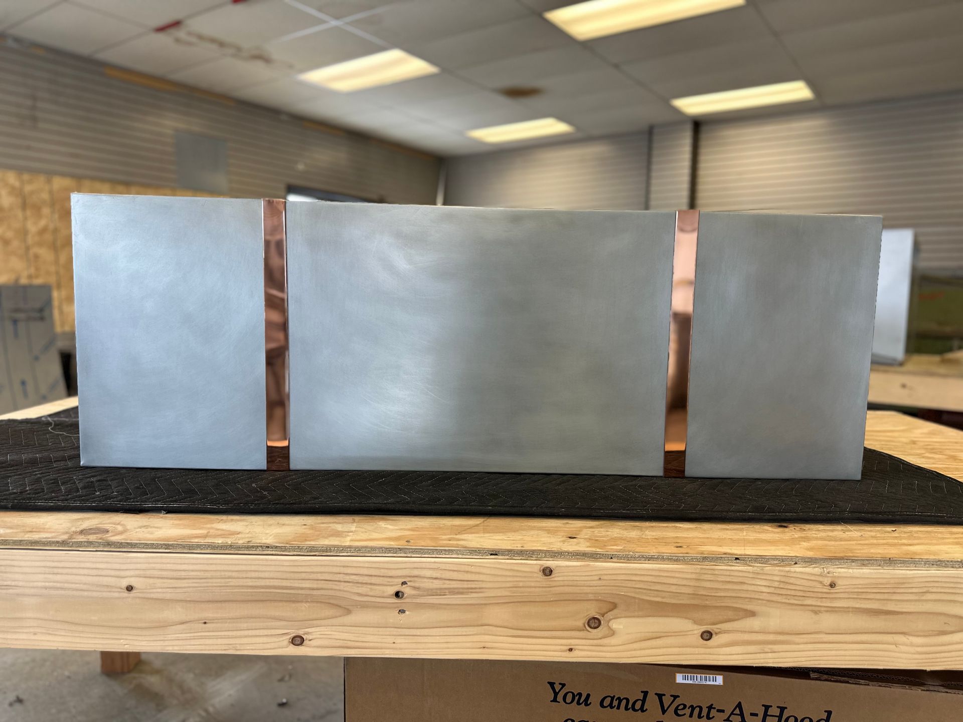 Three pieces of metal sitting on top of a wooden table