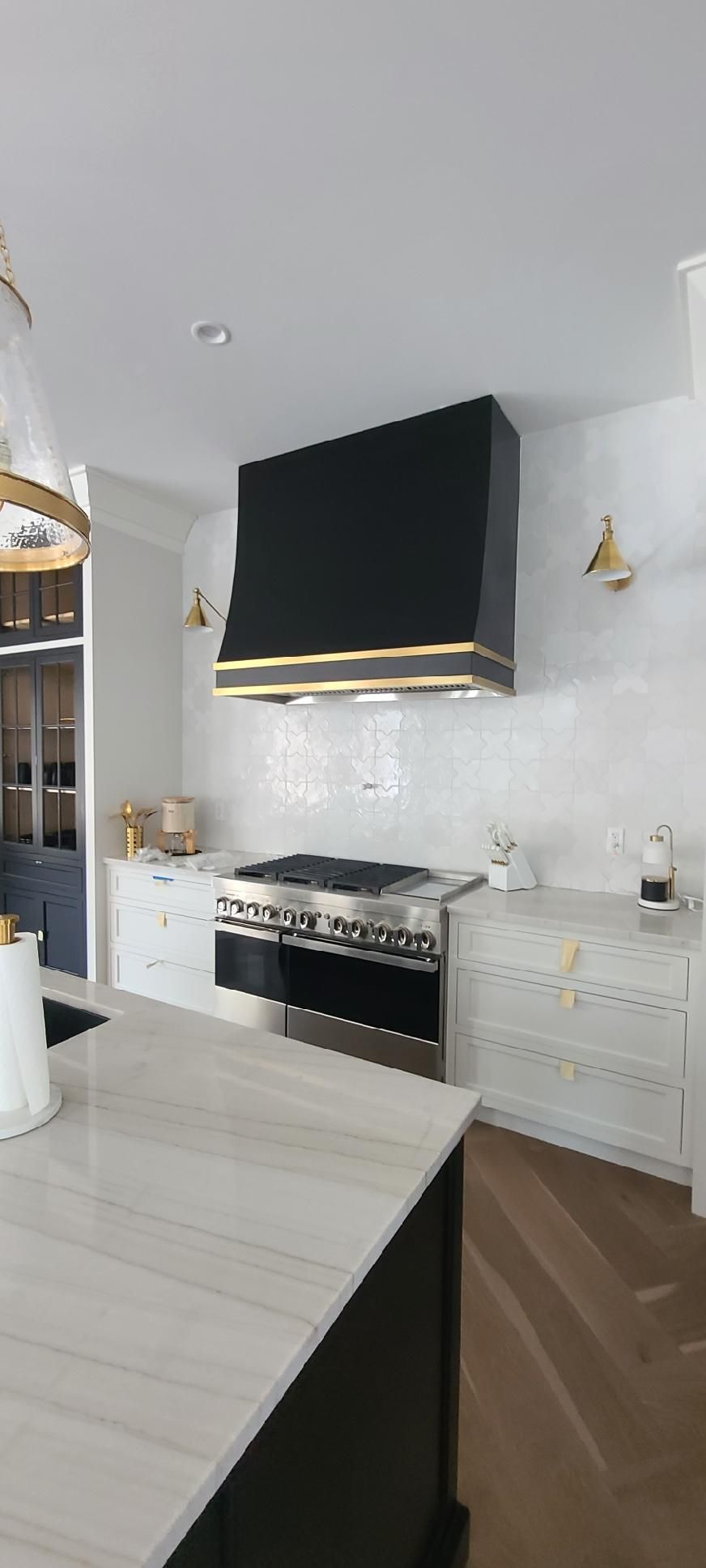A kitchen with a black stove top oven and a black hood.