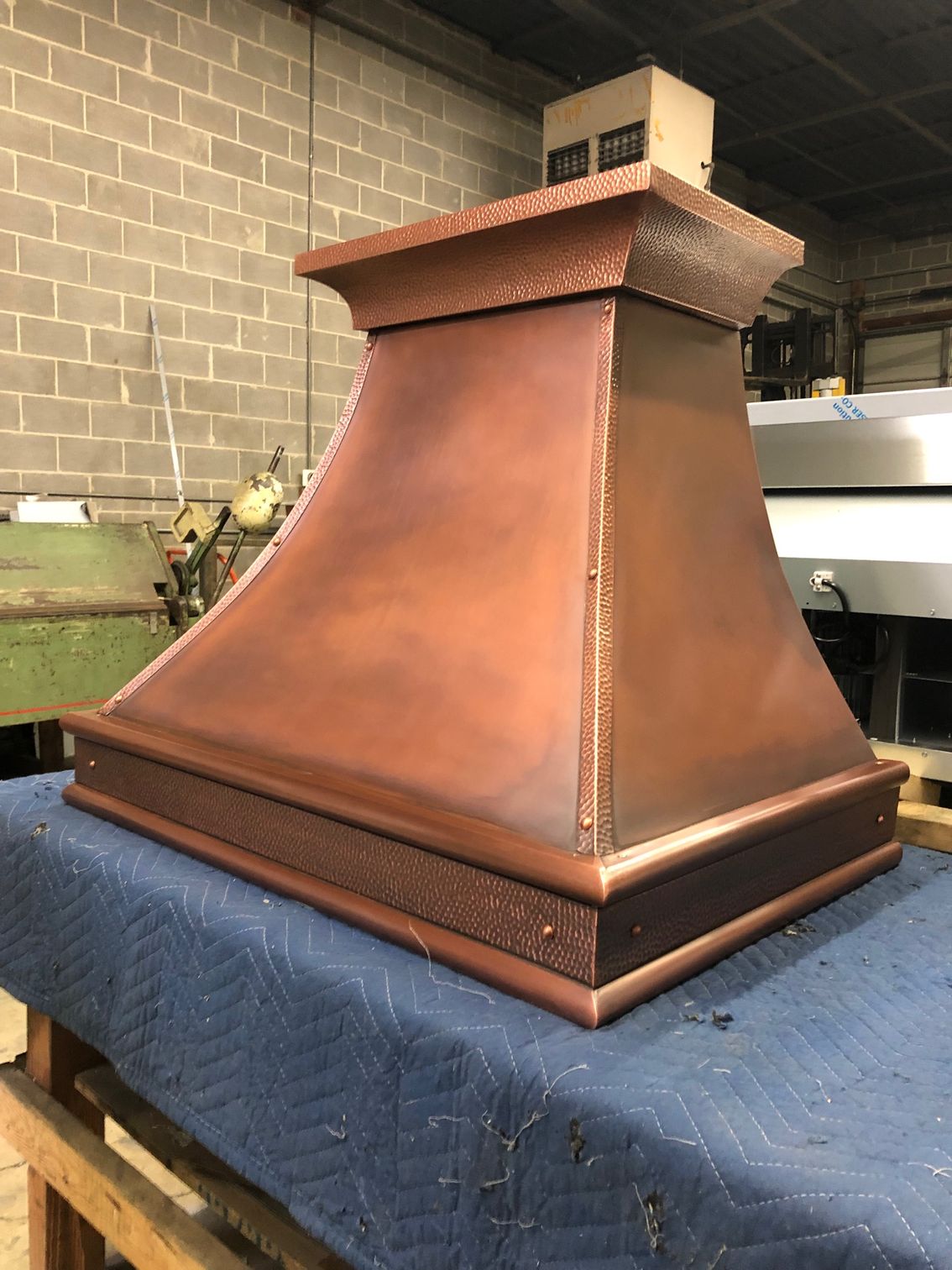 A copper hood is sitting on top of a blue table.