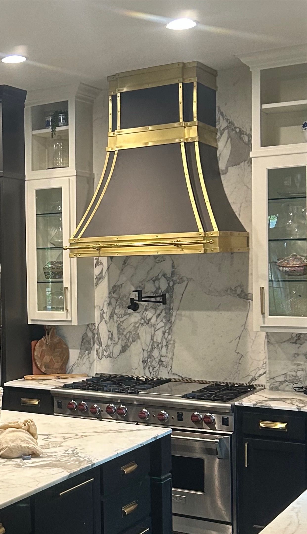 A kitchen with a stove and a hood above it.