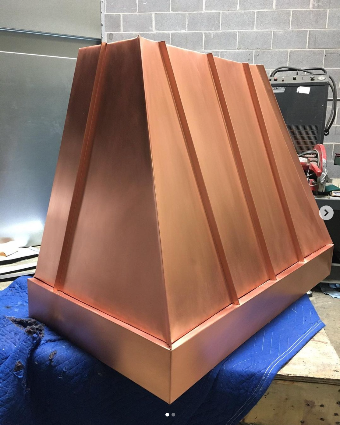 A large copper object is sitting on a blue blanket