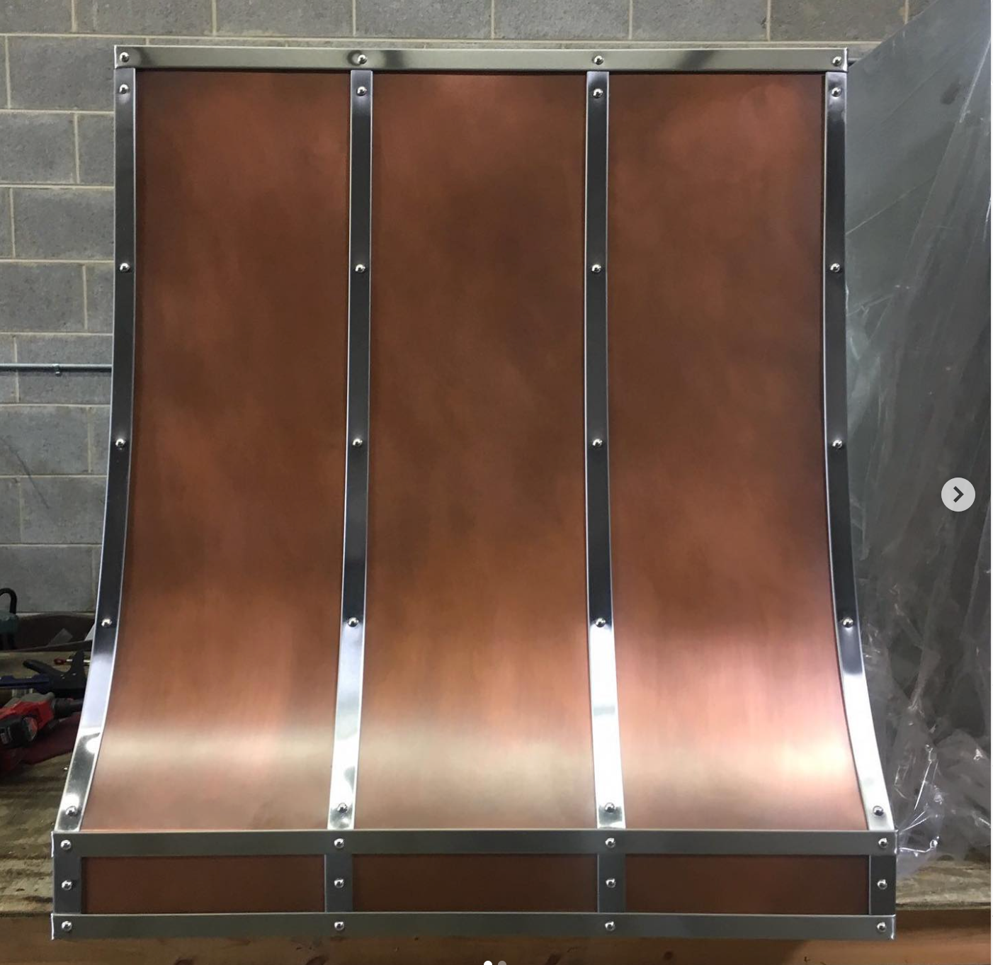 A copper hood is sitting on a wooden table