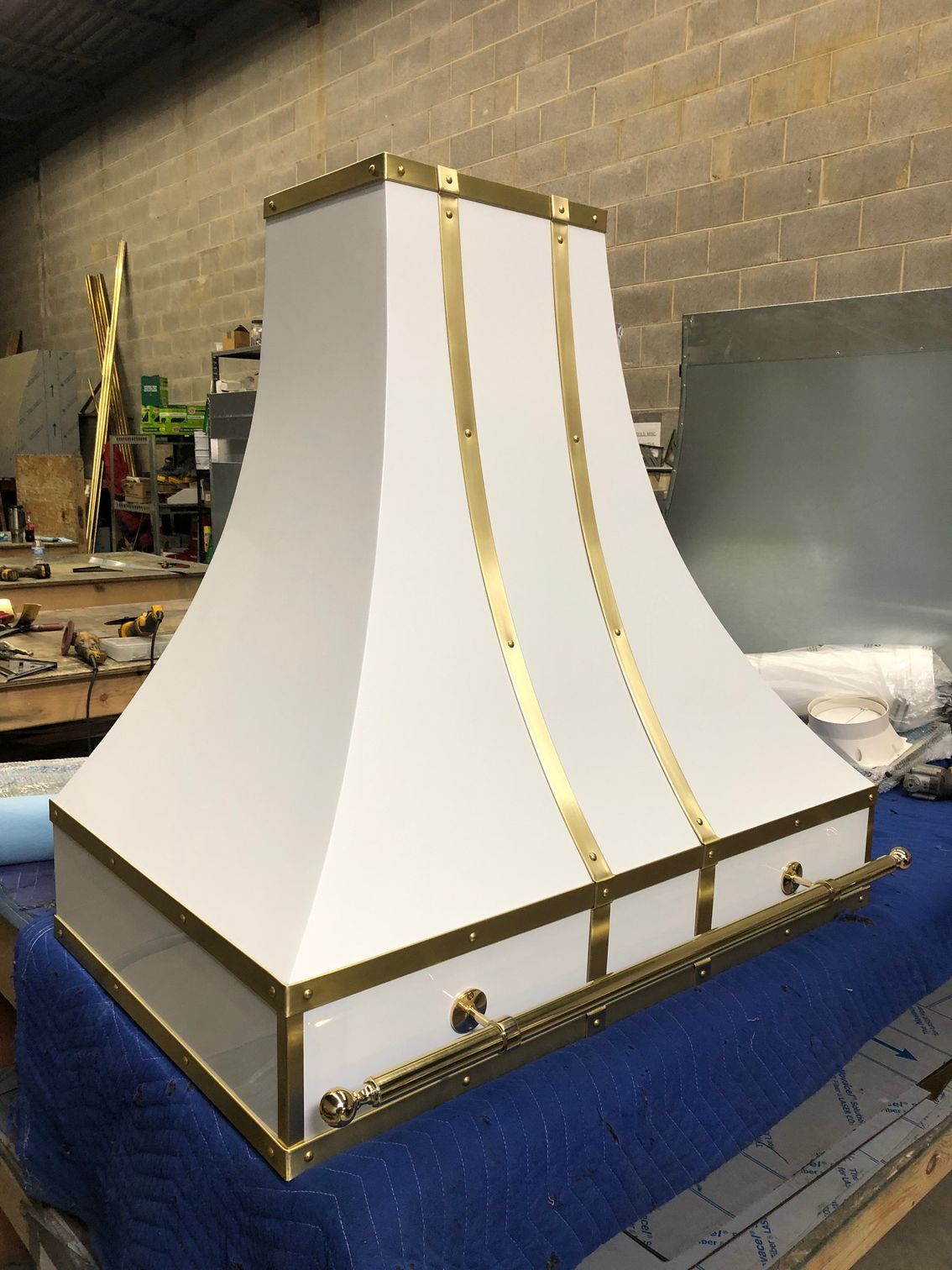 A white hood with gold trim is sitting on a blue table.
