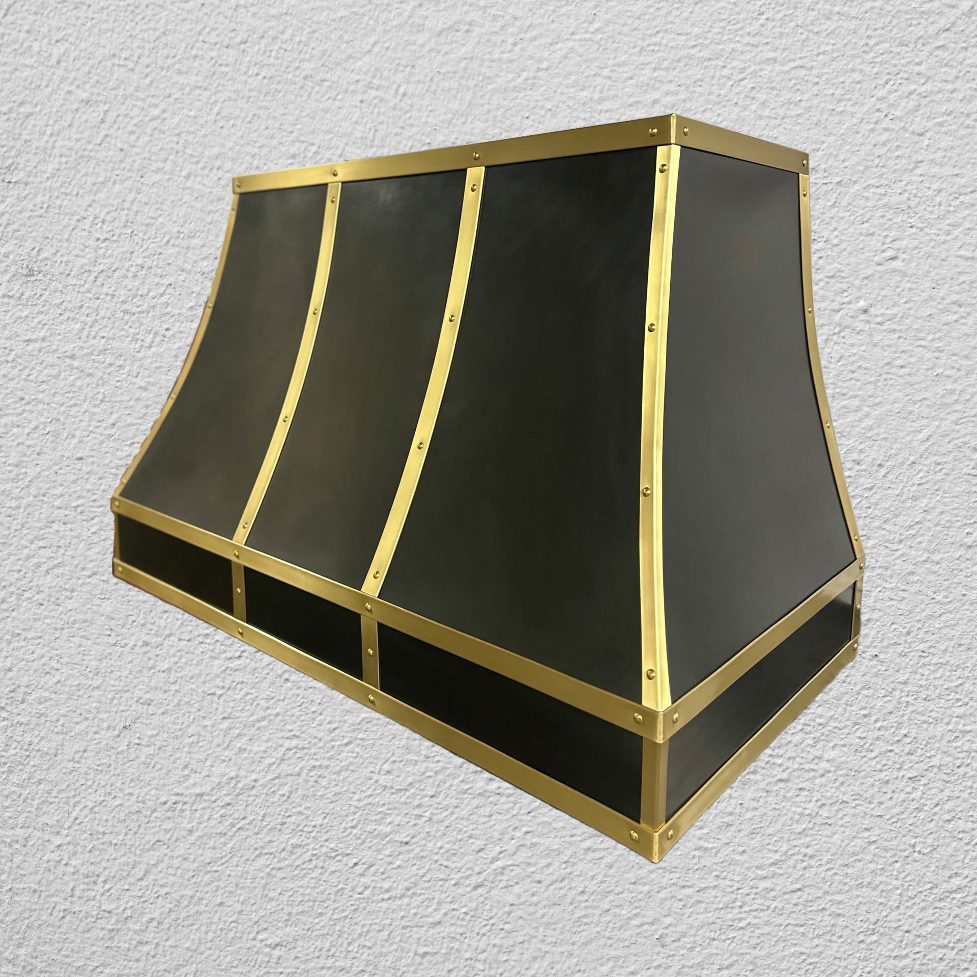 A black and gold hood is hanging on a white wall