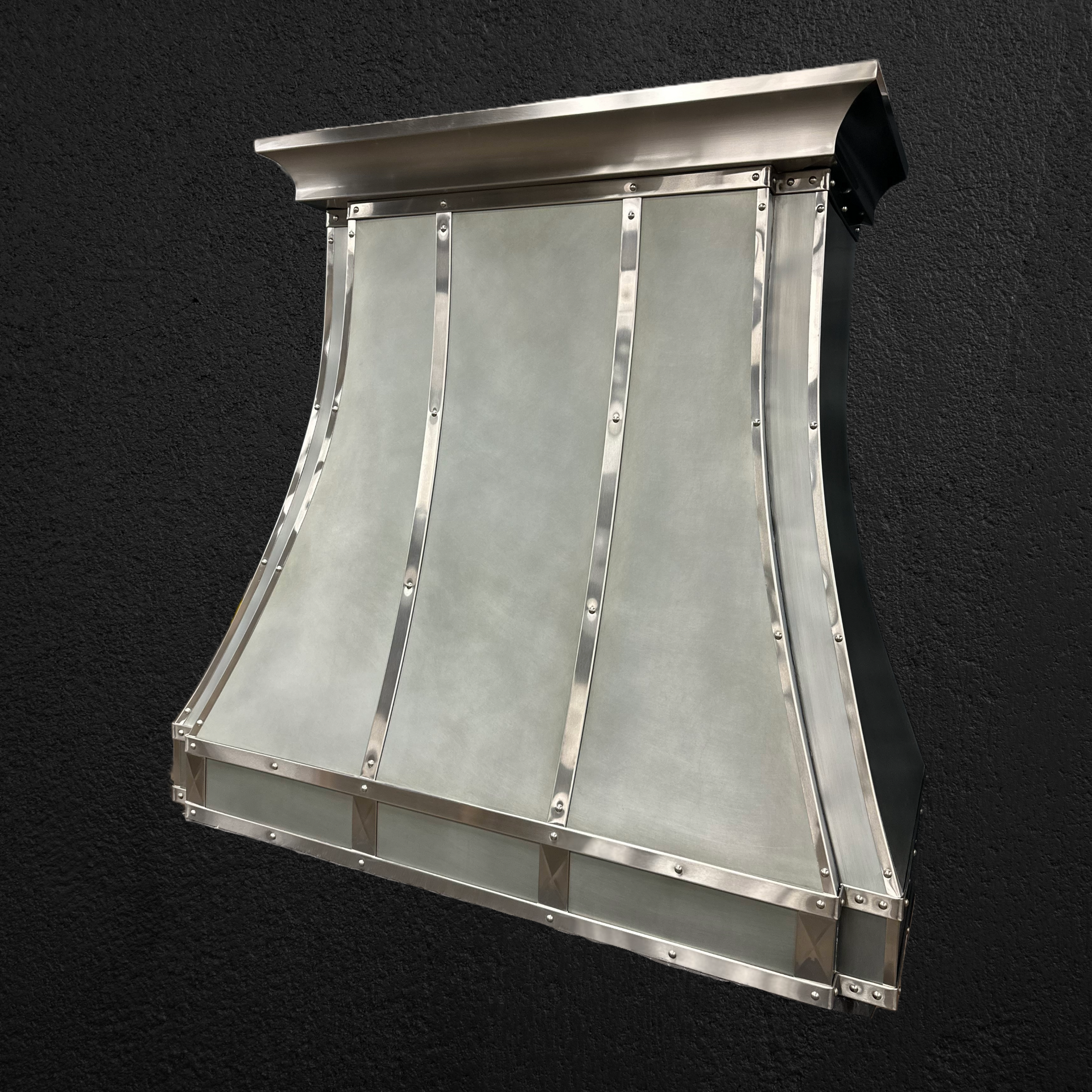 A stainless steel hood is sitting on a black surface