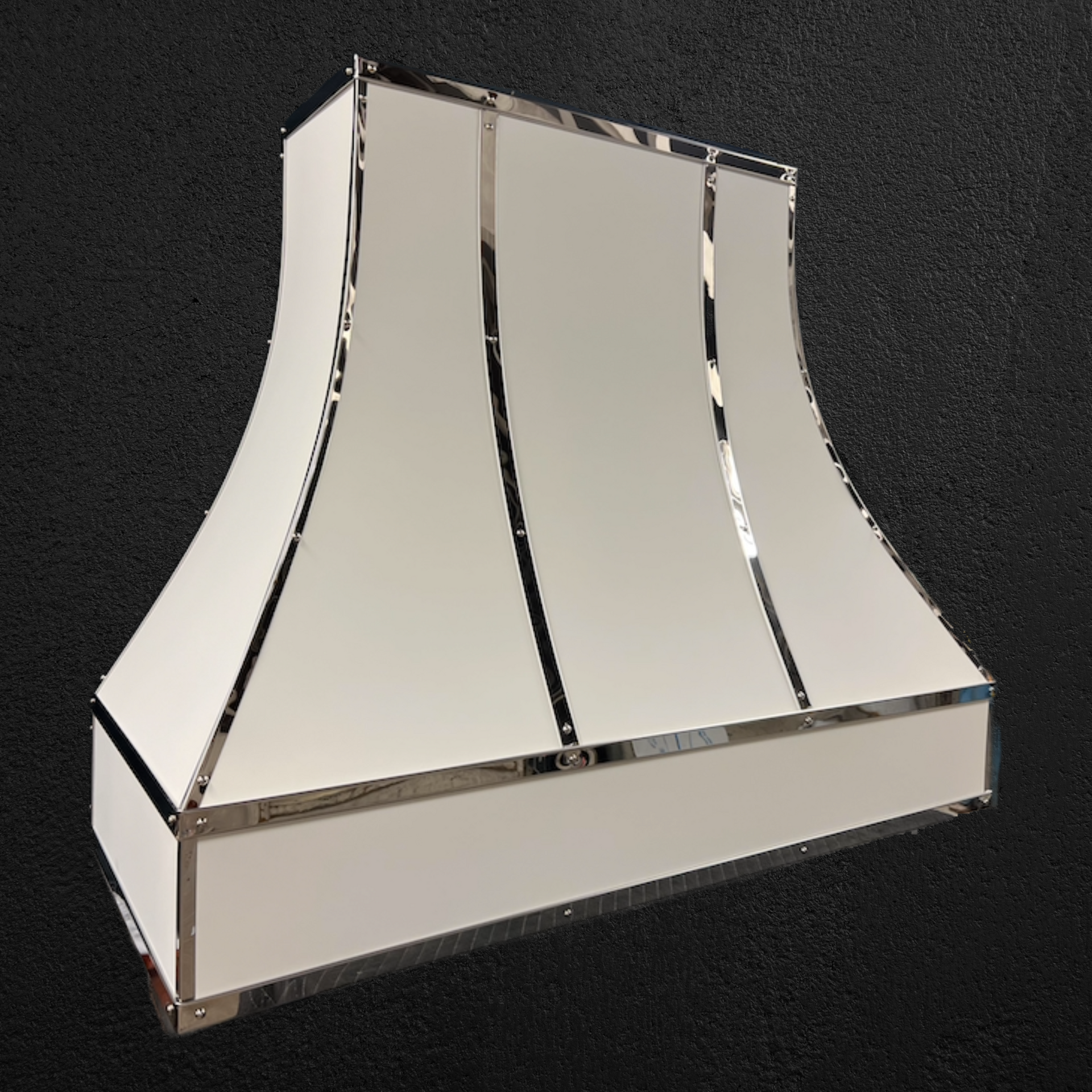 A white hood with chrome trim is sitting on a black surface