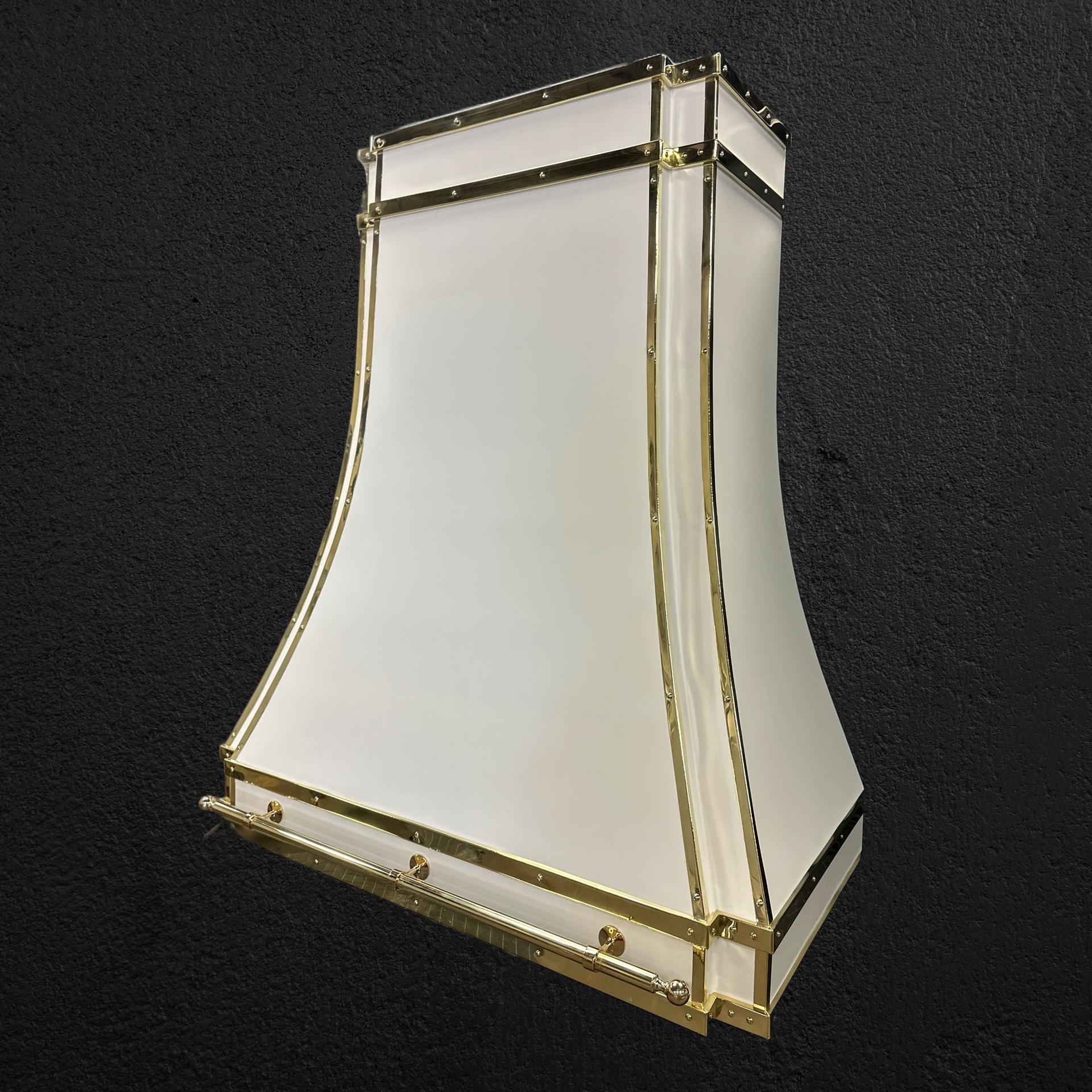A white lamp with gold trim is sitting on a black surface