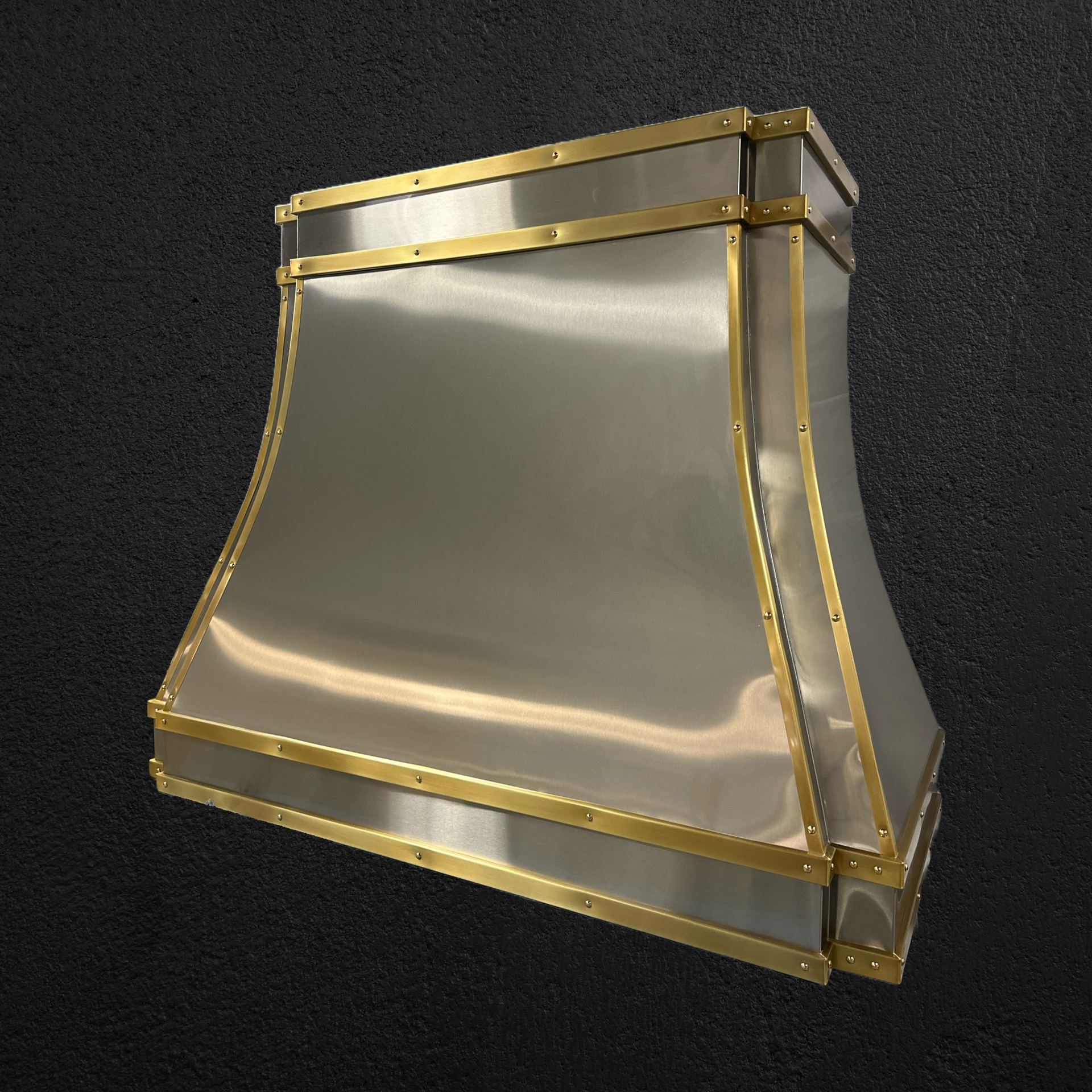 A stainless steel hood with gold trim on a black background
