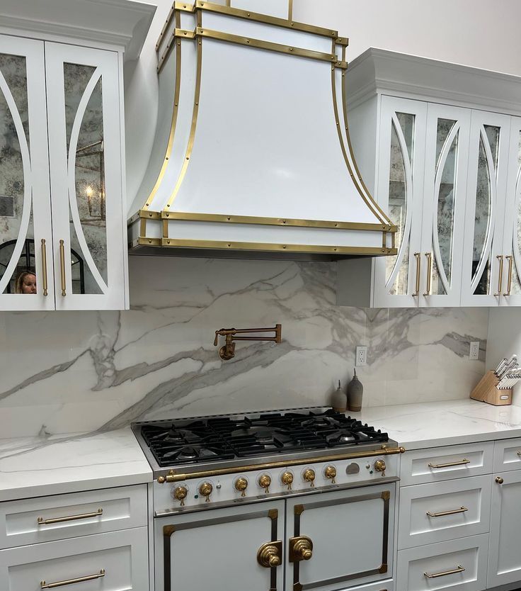 A kitchen with white cabinets and a stove top oven