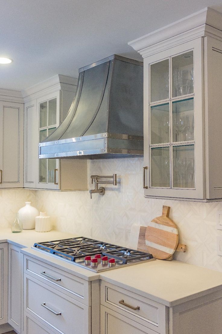 A kitchen with white cabinets and a stove top oven.