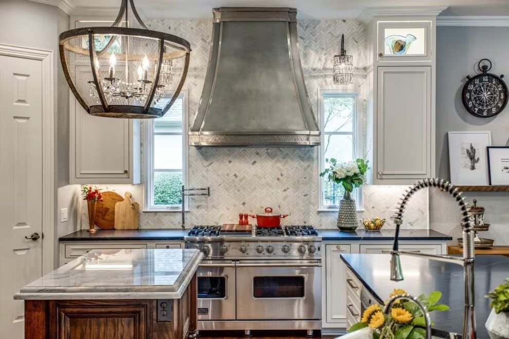 A kitchen with a stove , sink , and chandelier.