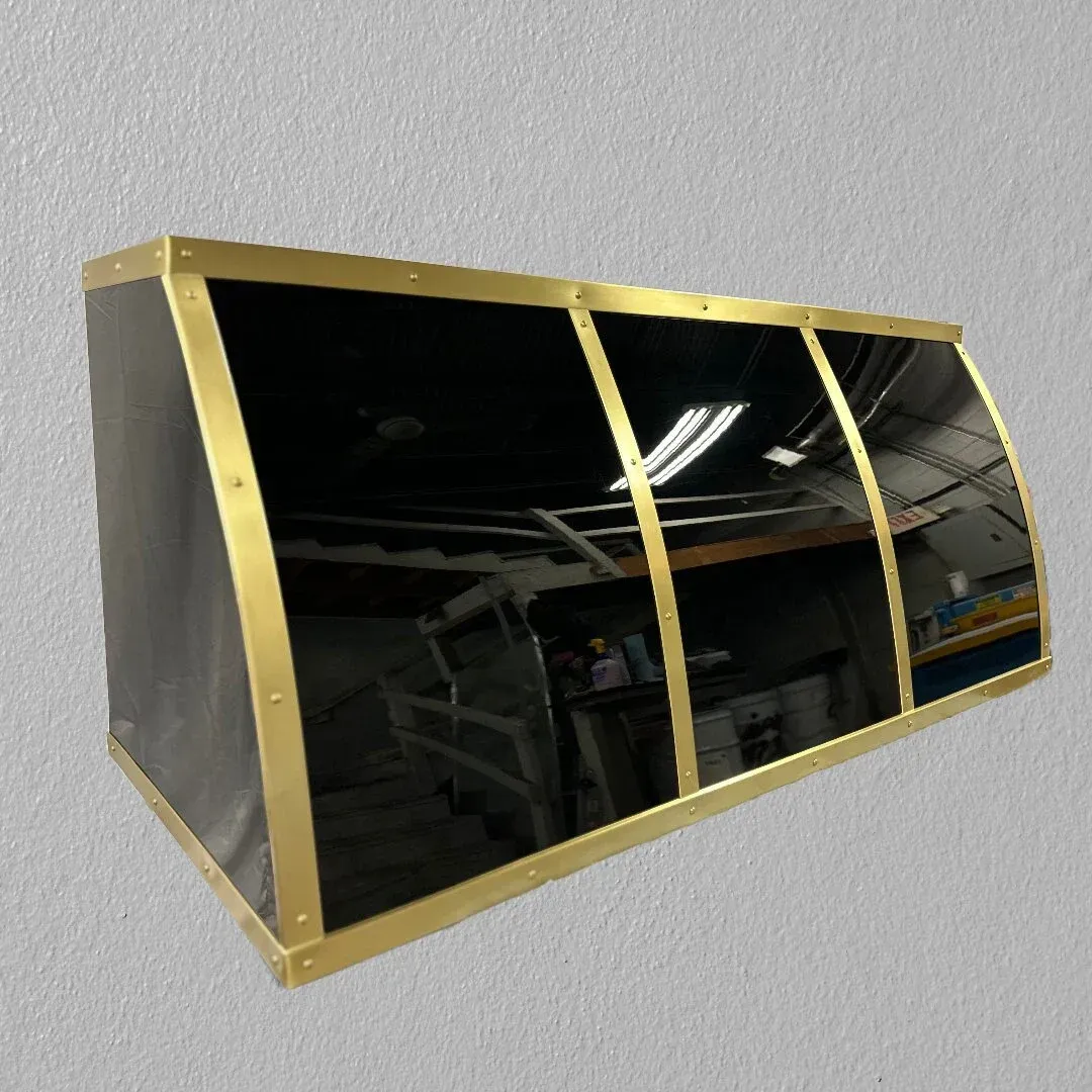 A black and gold awning is hanging on a white wall