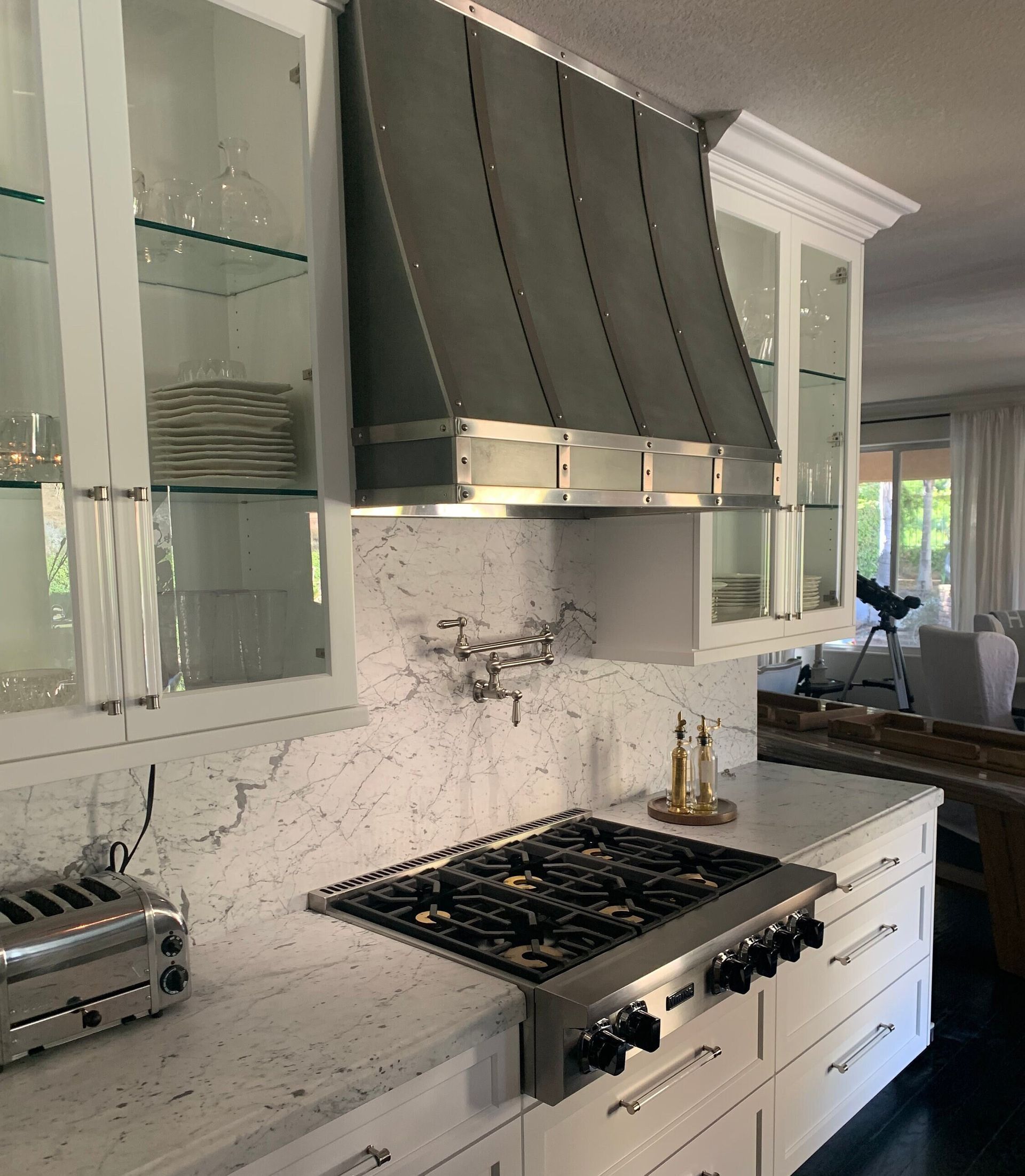 A kitchen with white cabinets and a stove top oven