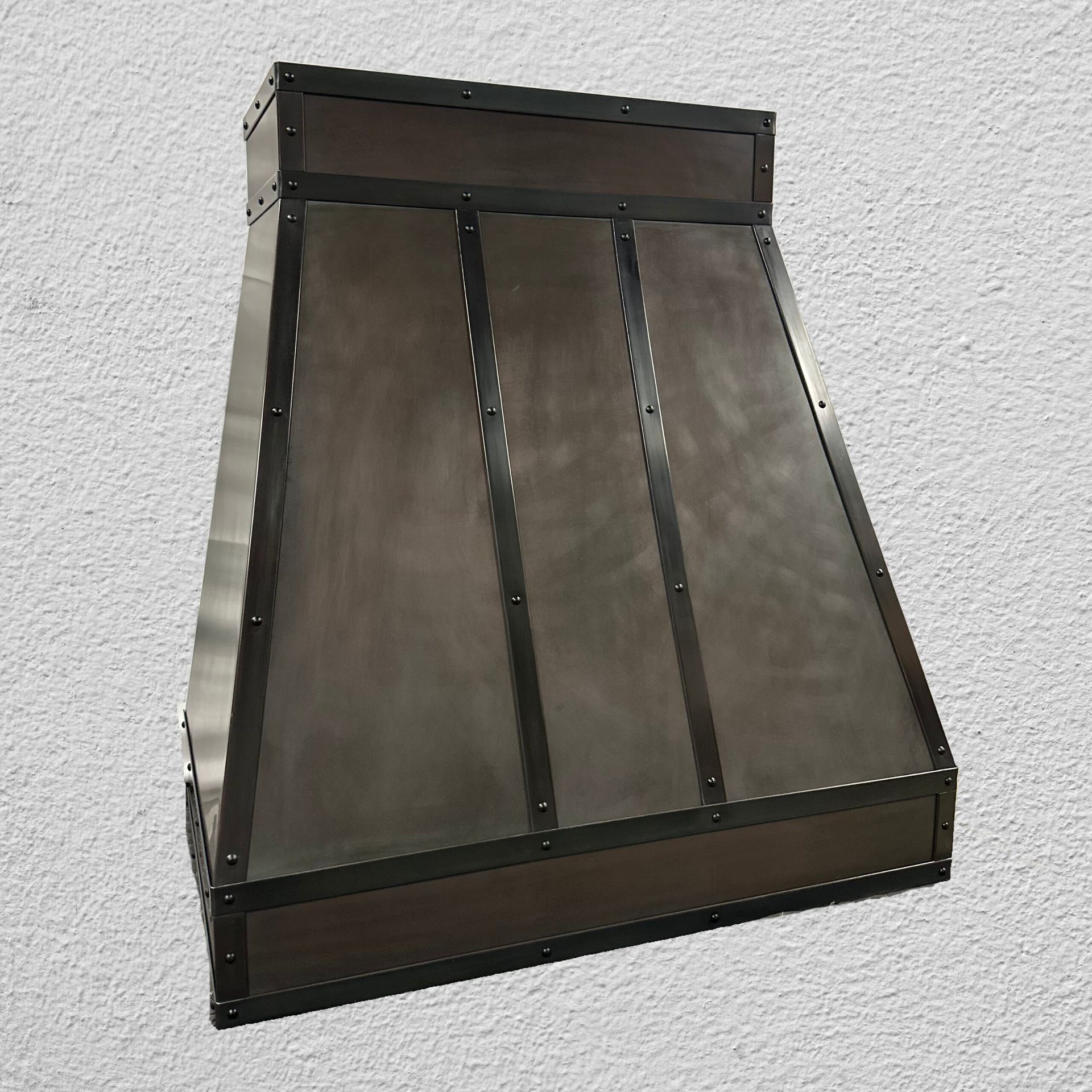 A metal hood is sitting on a white wall