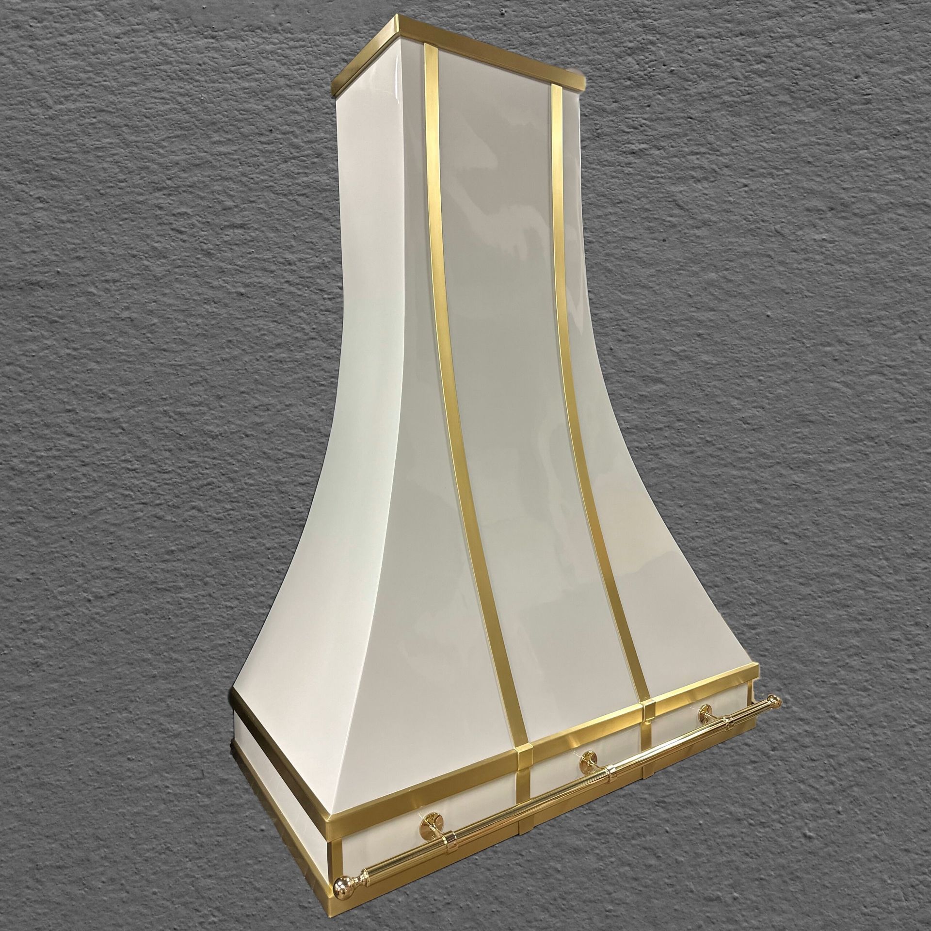 A white hood with gold trim is sitting on a gray surface