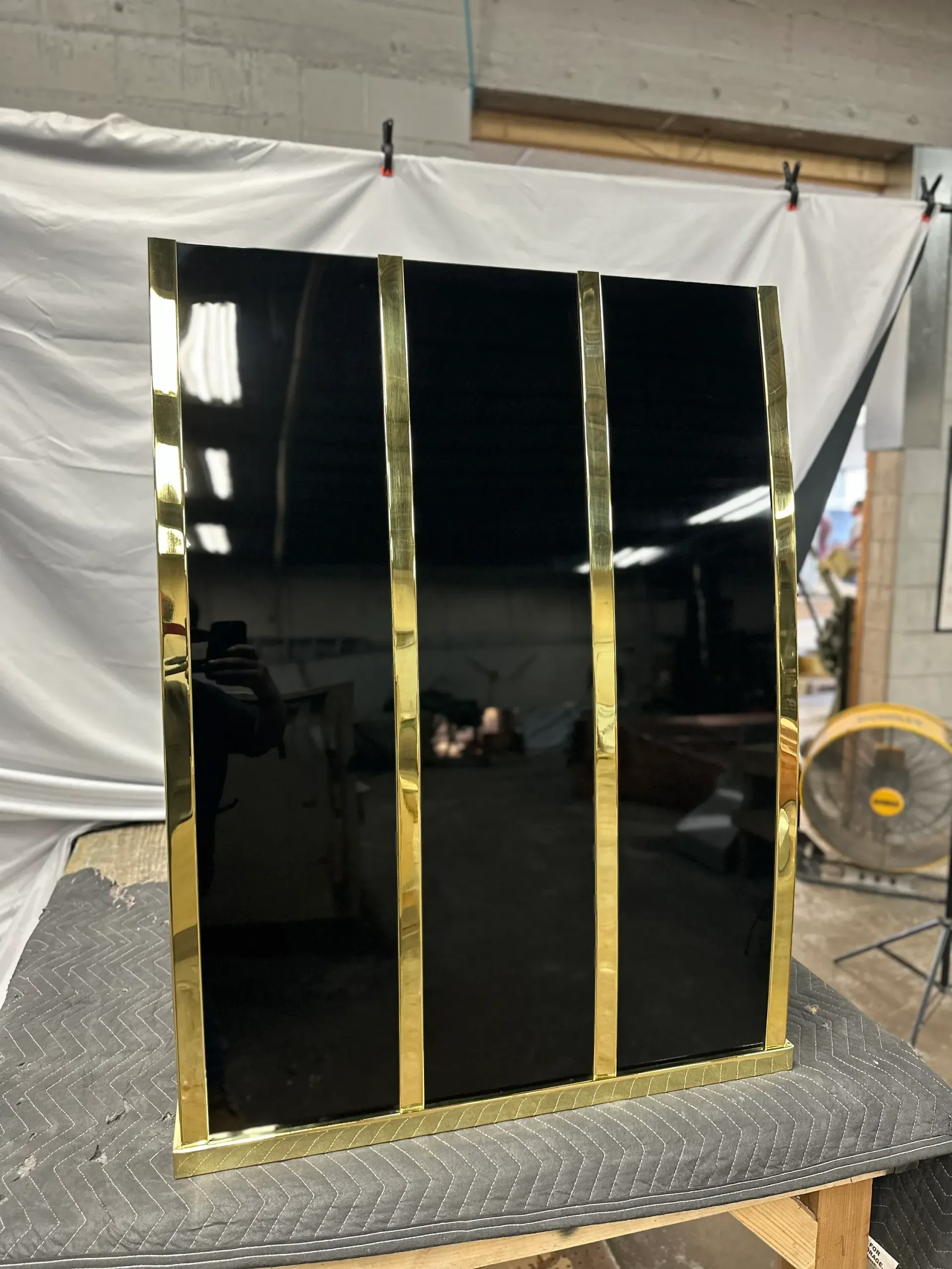 A black mirror with gold trim is sitting on a table