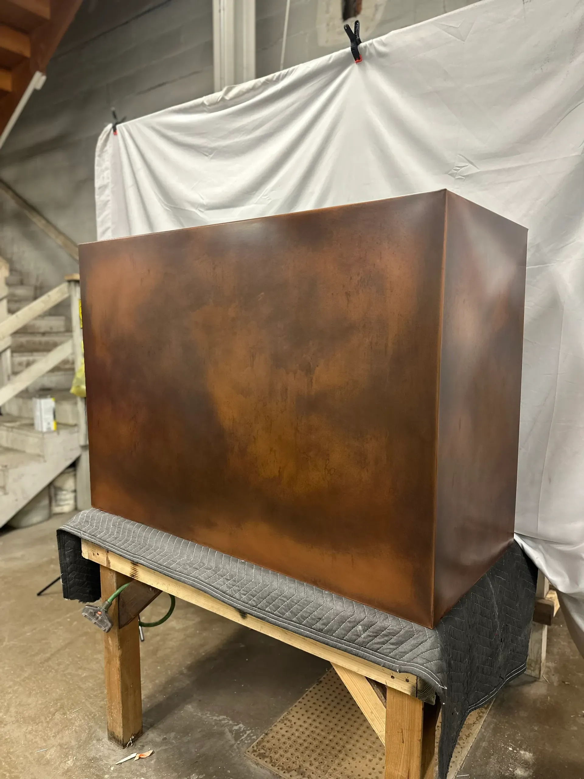 A large copper box is sitting on top of a wooden table.