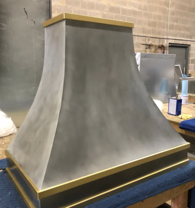 A gray and gold hood is sitting on a table