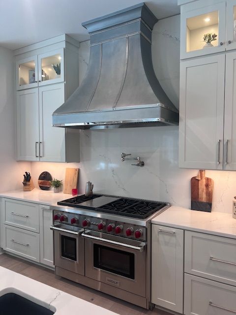A kitchen with stainless steel appliances and white cabinets