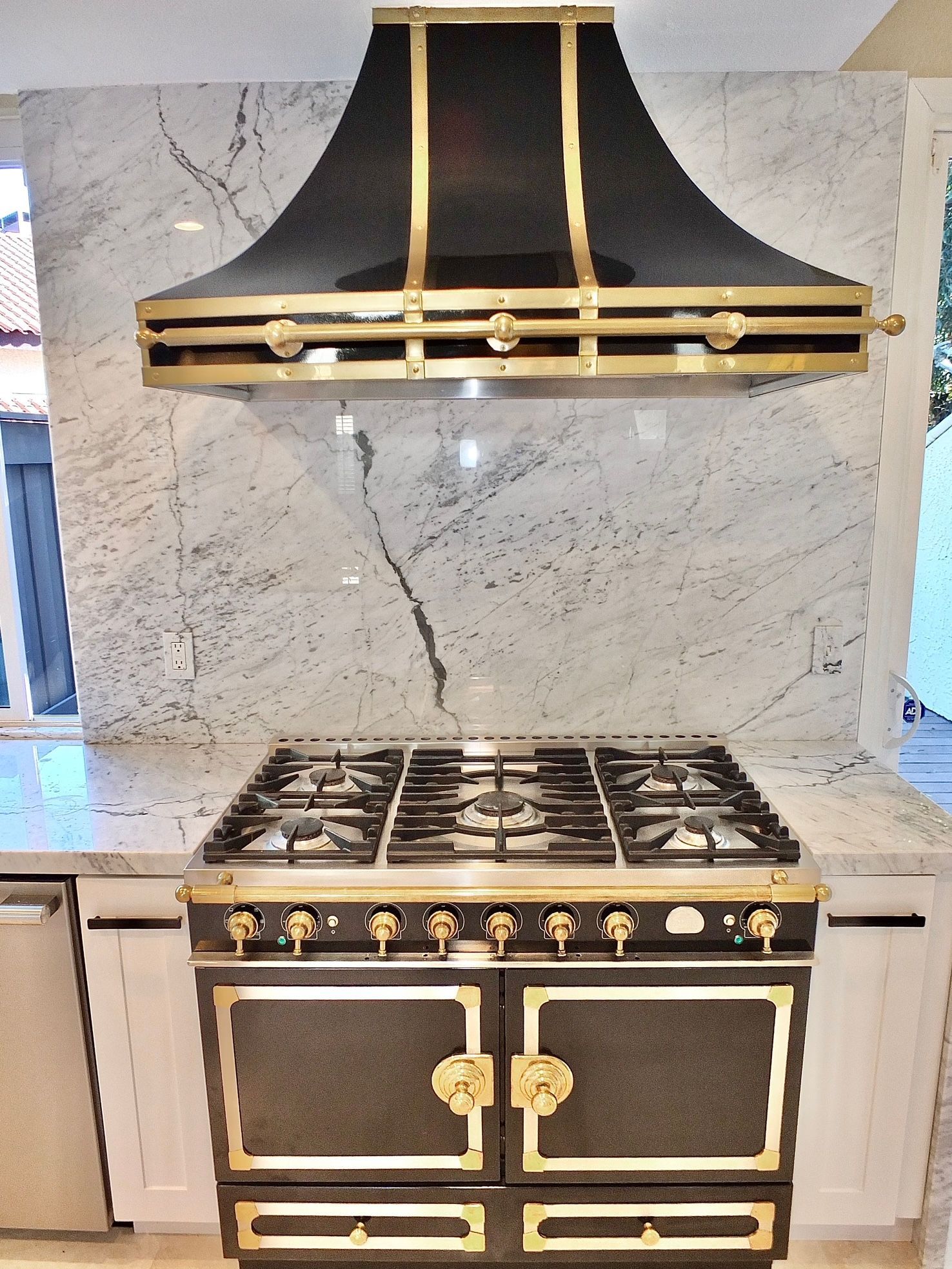 A black and gold stove with a hood above it