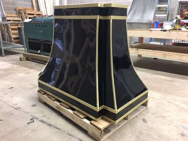 A black and gold item is sitting on a wooden pallet