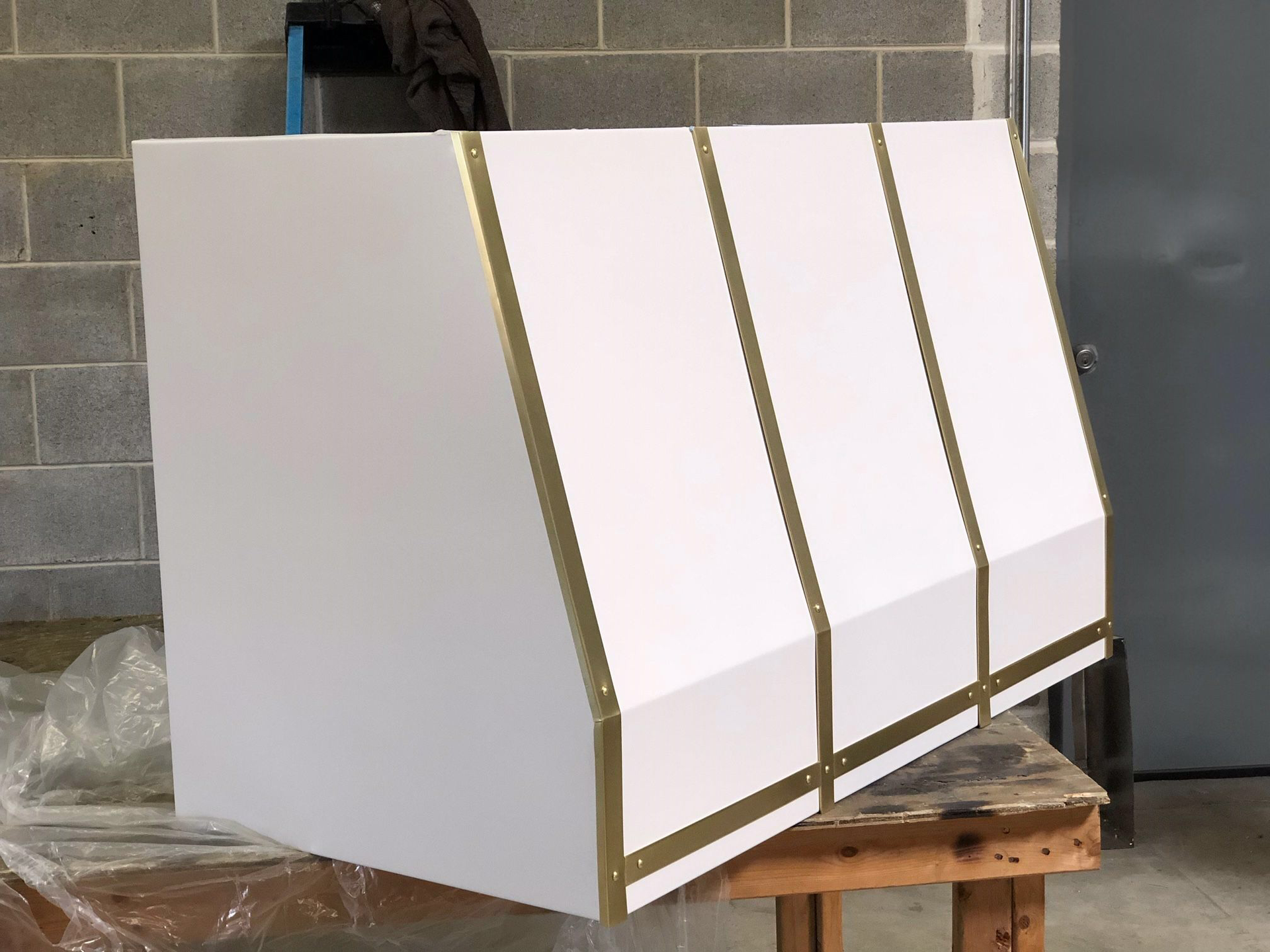 A white box with gold trim is sitting on a wooden table.
