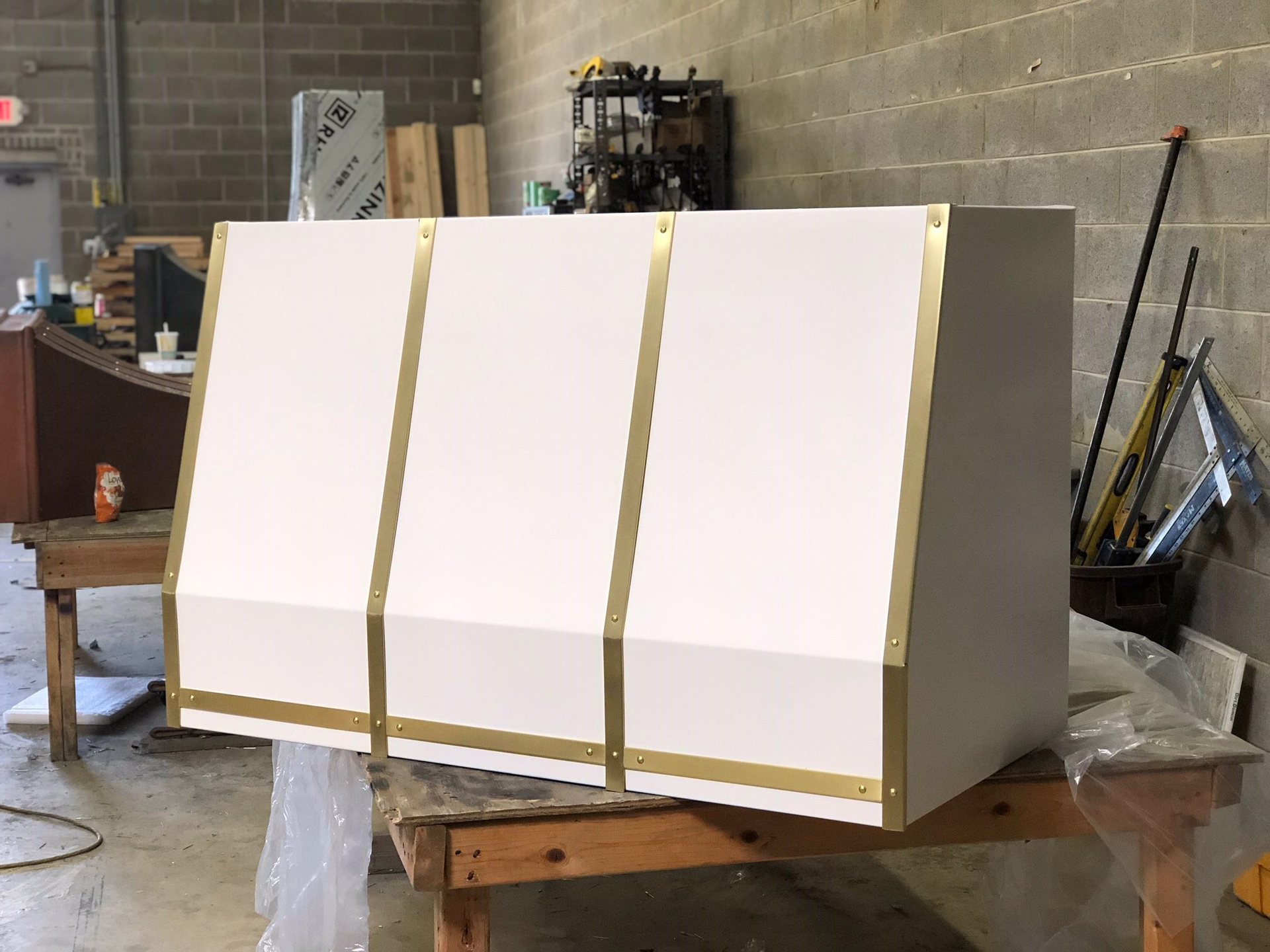 A white box with gold trim is sitting on a wooden table.