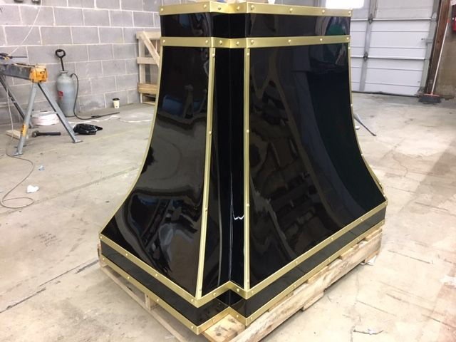 A black and gold item is sitting on a wooden pallet