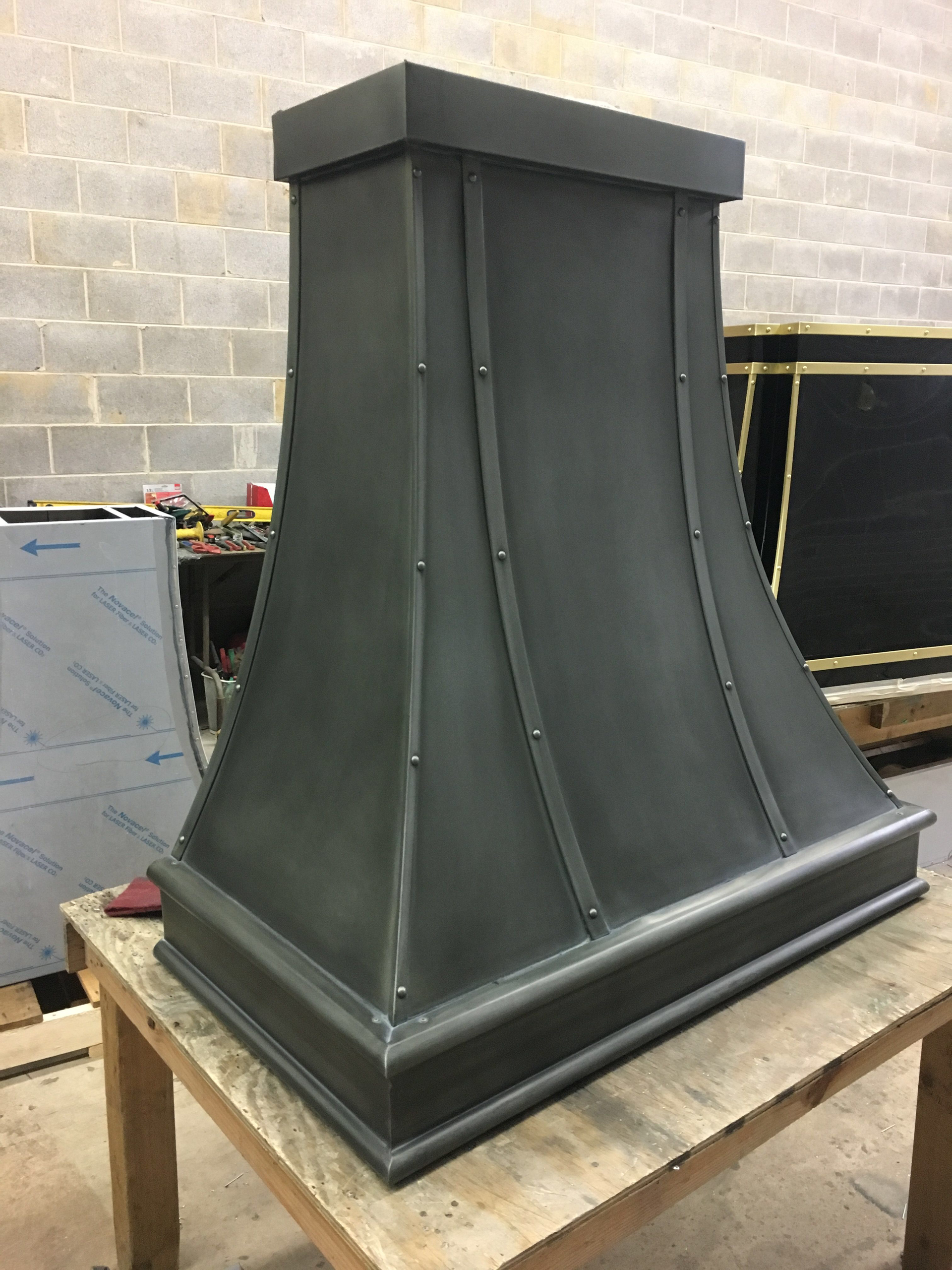 A black hood is sitting on top of a wooden table.