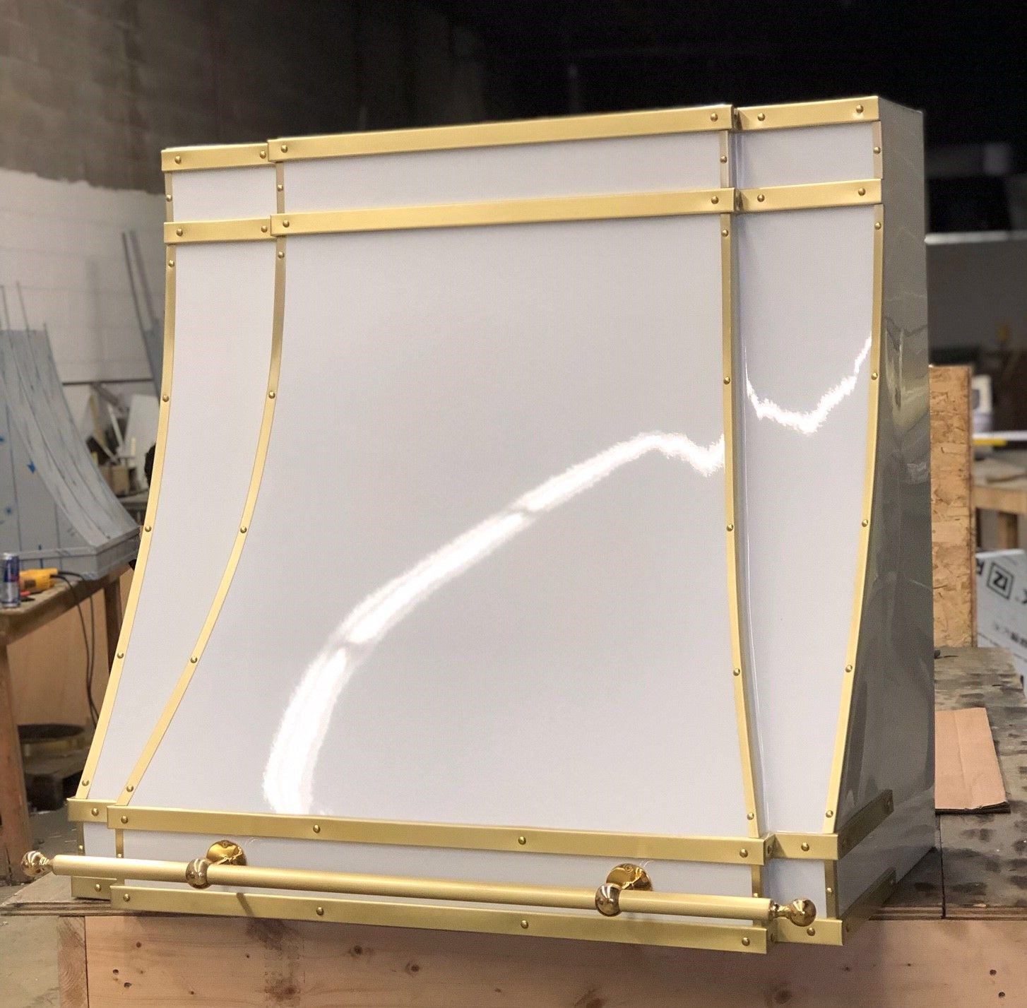 A white hood with gold trim sits on a wooden table