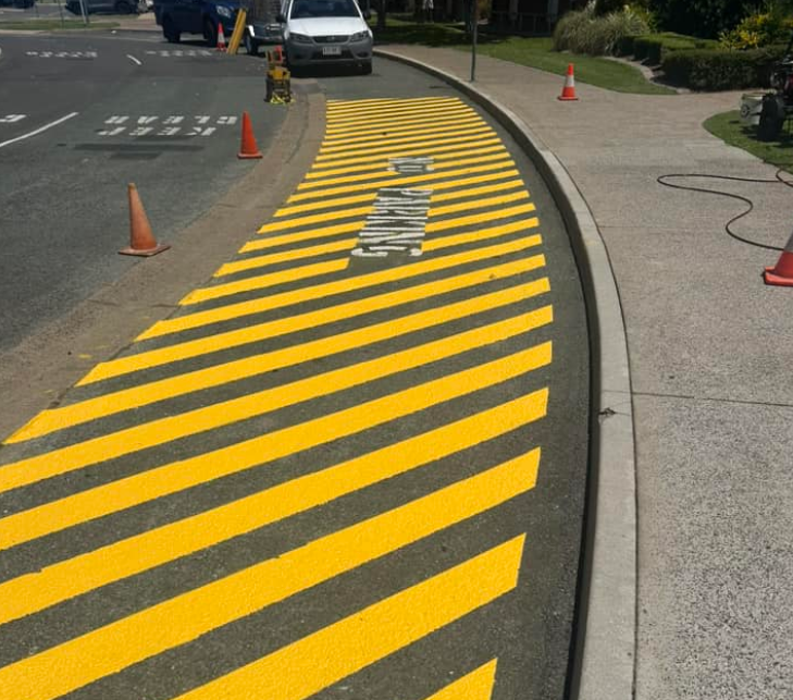 A Yellow And Black Striped Road With The Word Parking Painted On It — Wide Bay Line Marking in Hervey Bay, QLD