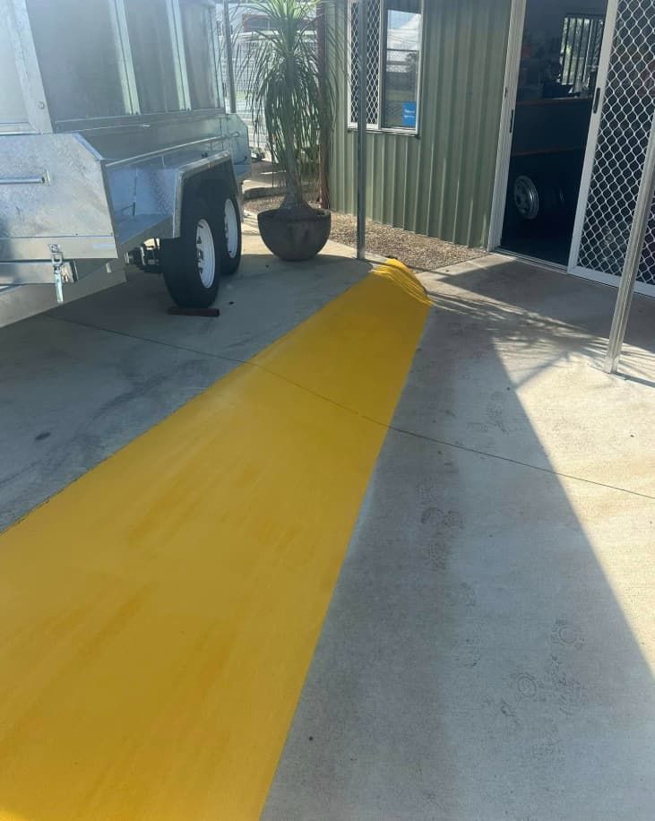 A Trailer Is Parked In A Parking Lot Next To A Yellow Curb — Wide Bay Line Marking in Bundaberg, QLD