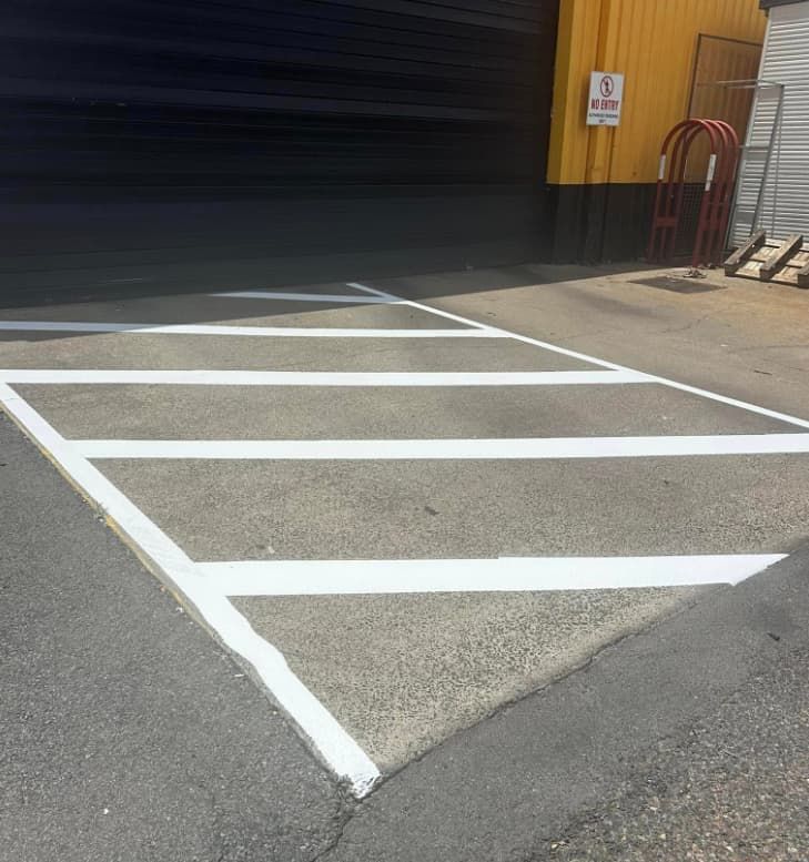 A Parking Lot With White Lines Painted On It — Wide Bay Line Marking in Wondunna, QLD