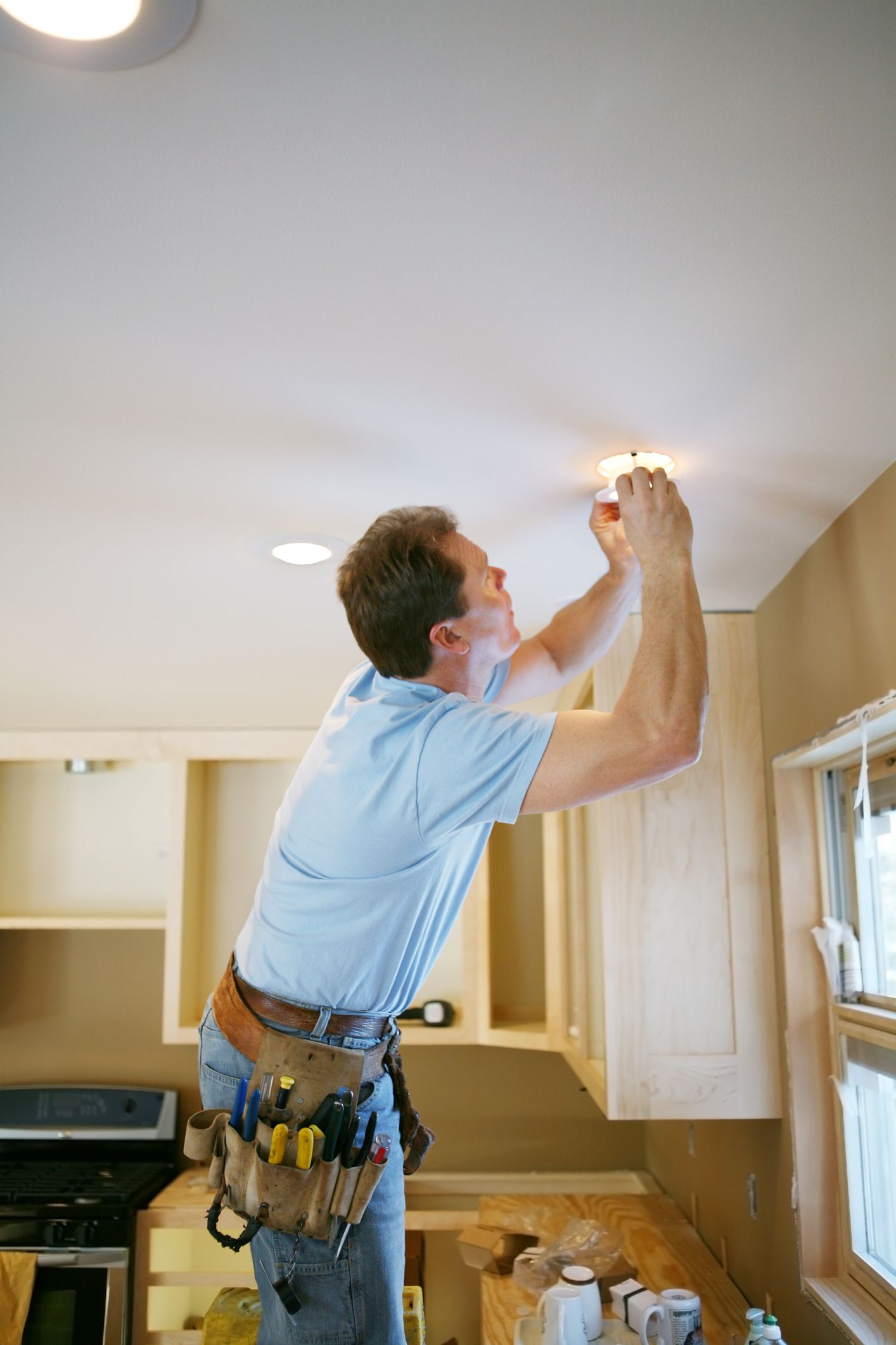 Man is installing a light fixture in the kitchen Man is installing a light fixture in the kitchen