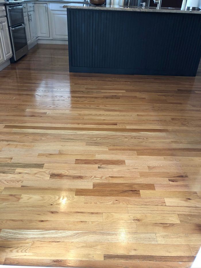 A kitchen with hardwood floors and a blue island.