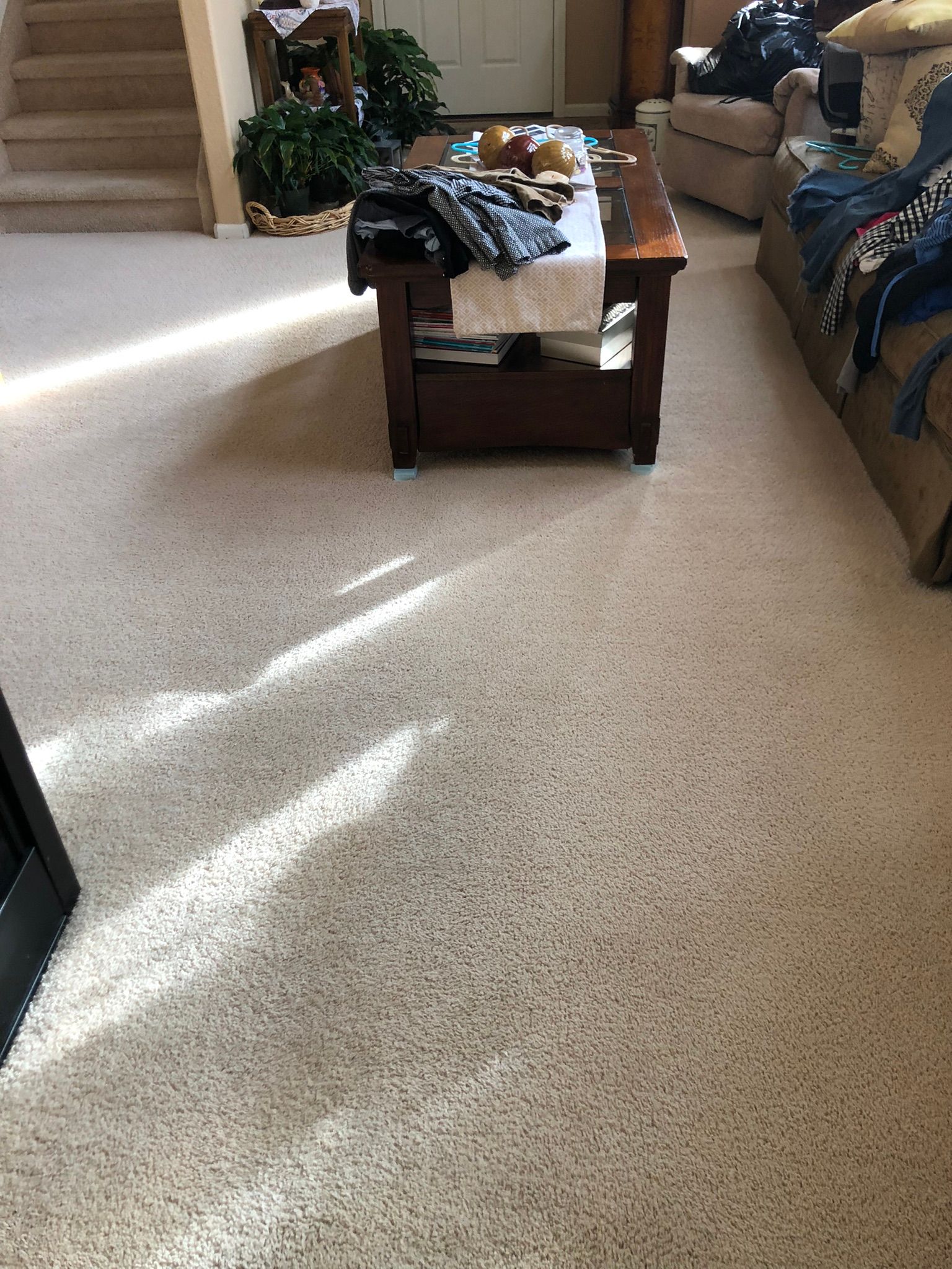A living room with a coffee table , couch , and stairs.