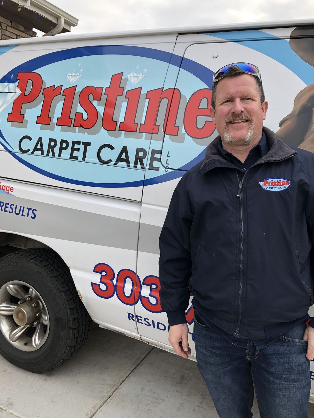 A man is standing in front of a pristine carpet care van