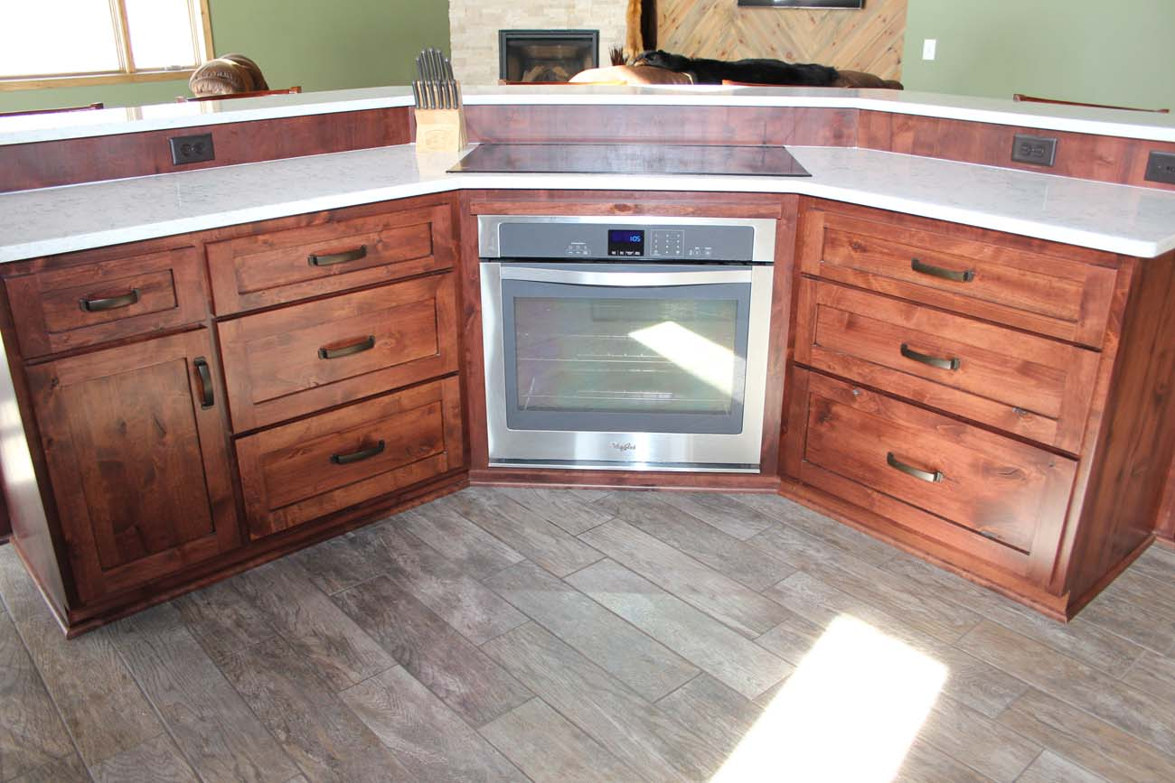 A kitchen with wooden cabinets and a stainless steel oven.