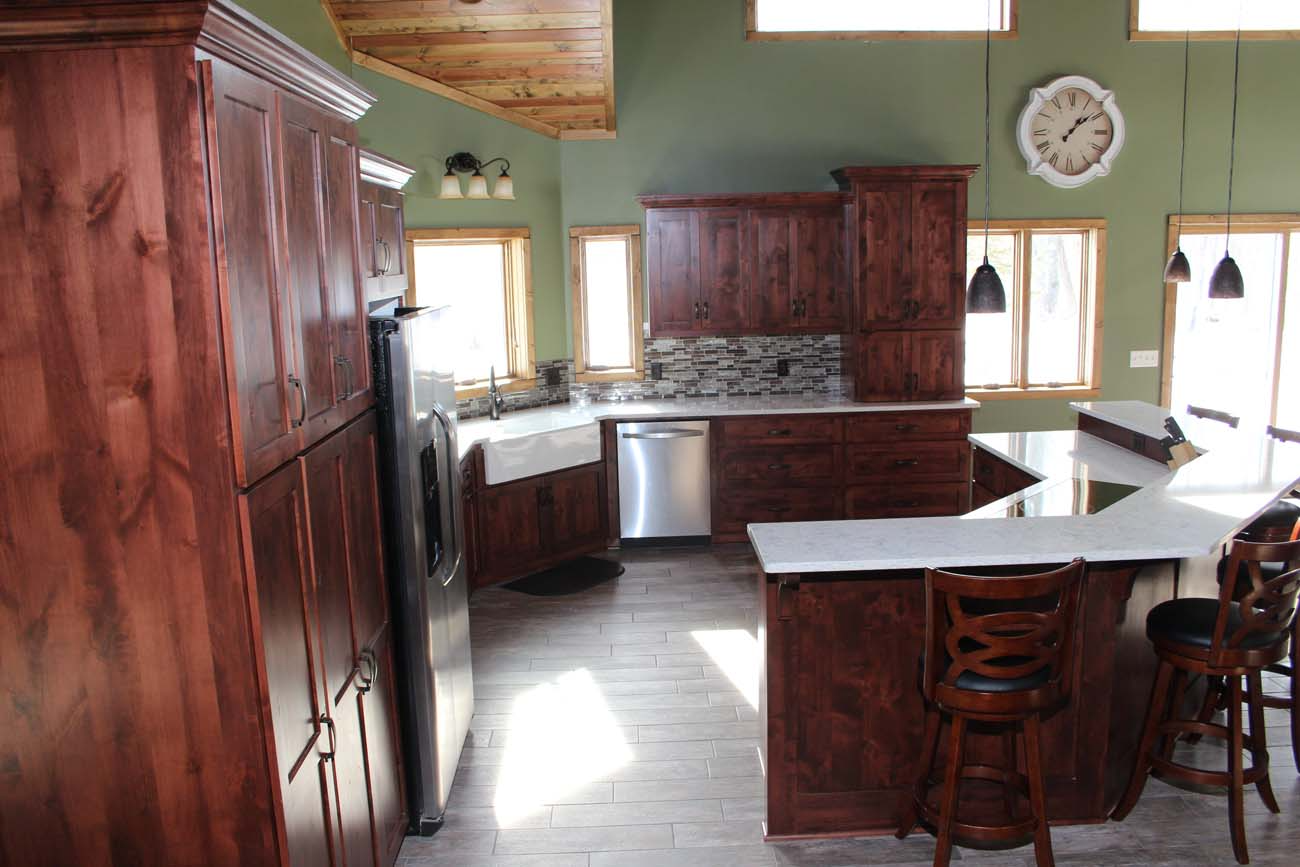 A kitchen with wooden cabinets and a clock on the wall