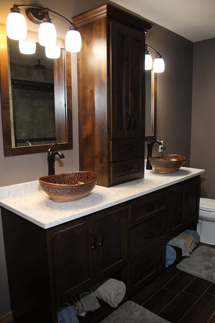 A bathroom with two sinks , two mirrors and a toilet.