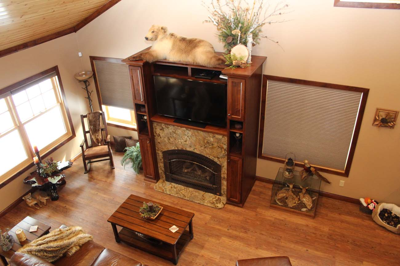 A dog is laying on top of a television in a living room