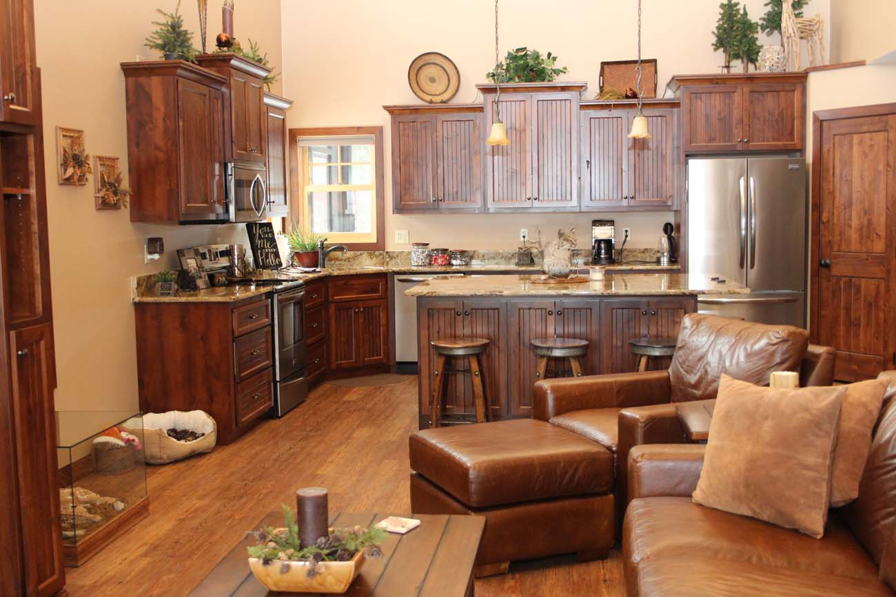 A living room filled with furniture and a kitchen with stainless steel appliances