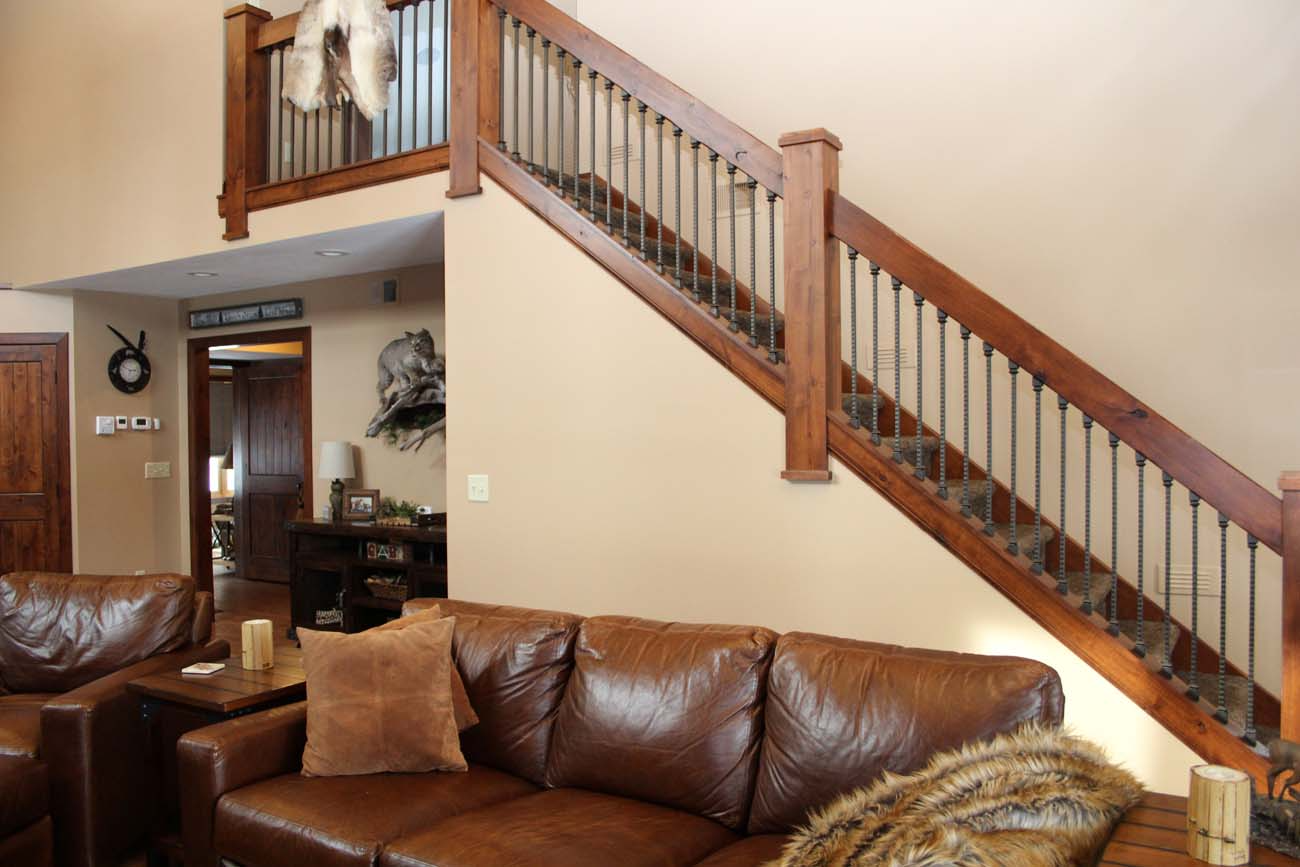 A living room with a couch and stairs leading up to the second floor