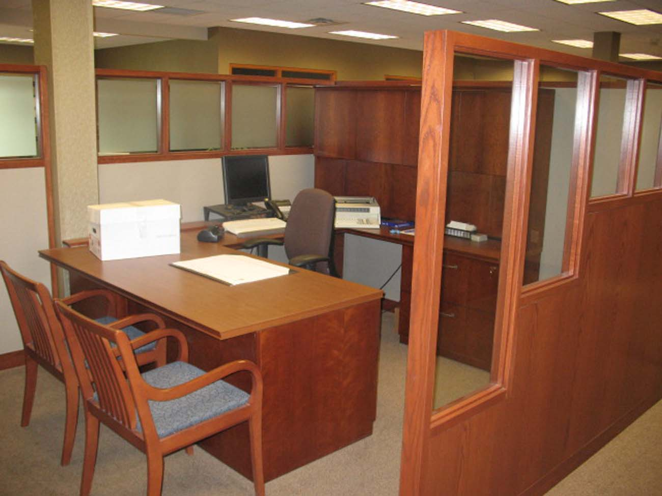 An office with a desk and chairs and a printer