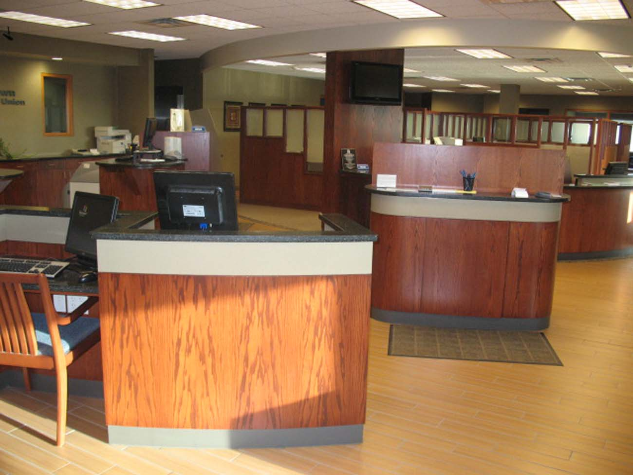 A bank with a lot of wooden counters and desks