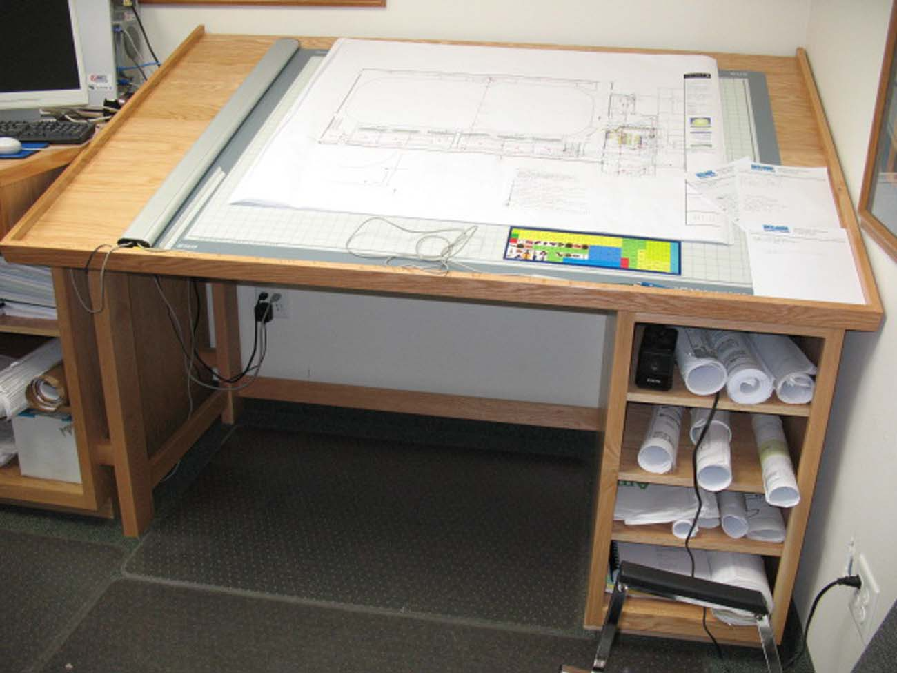 A wooden desk with rolls of paper on it