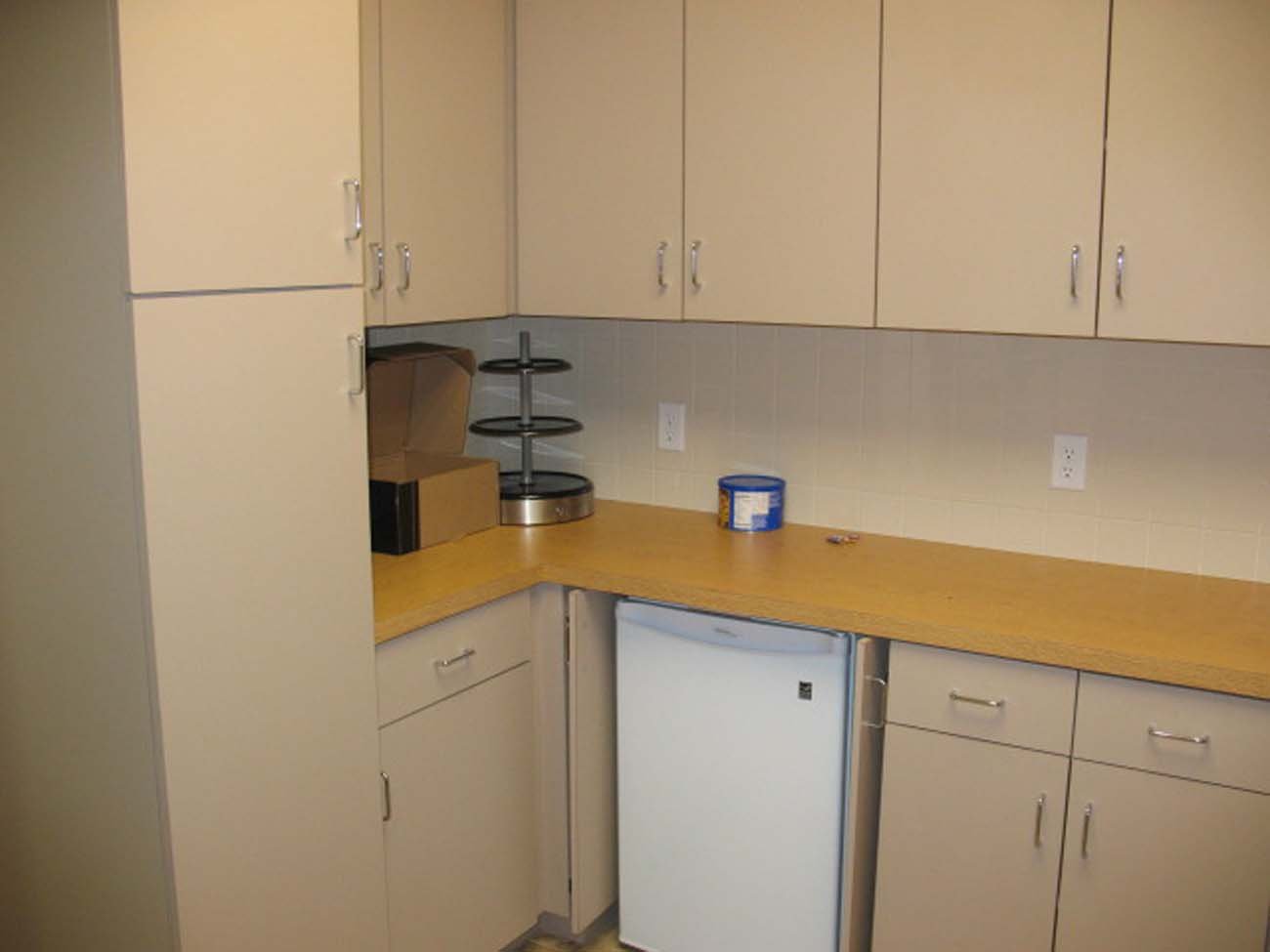 A kitchen with white cabinets and a white dishwasher